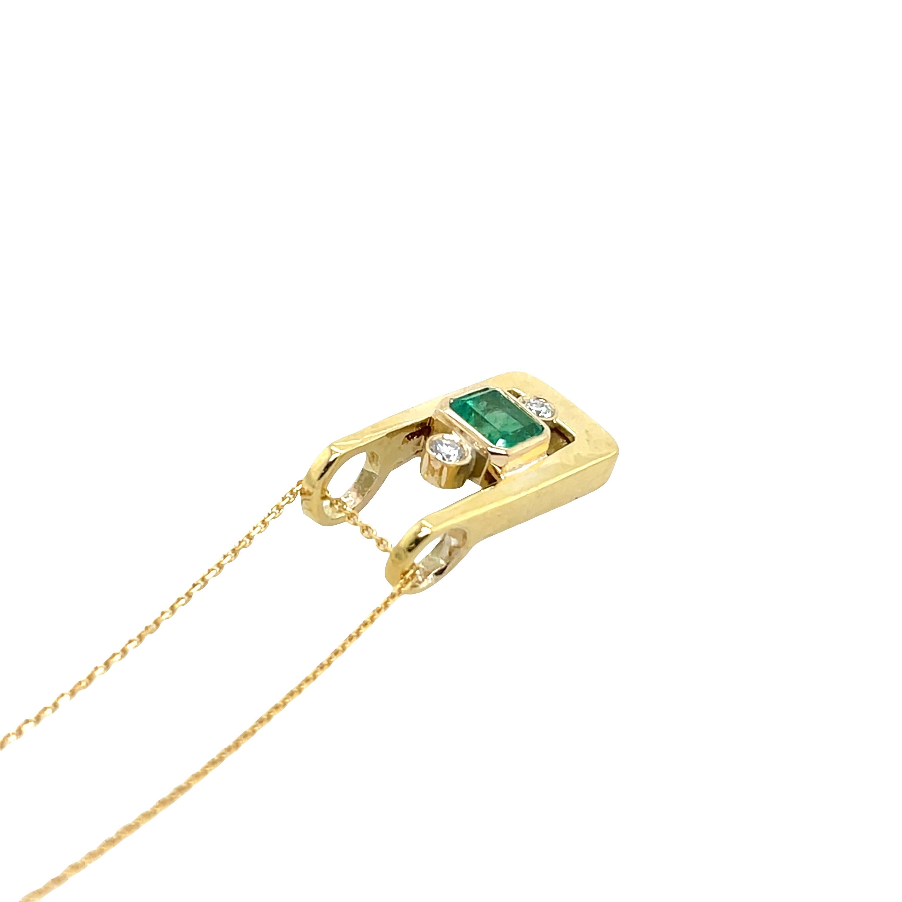 Ce superbe pendentif met en valeur une émeraude vibrante, 
élégamment associé à deux diamants ronds naturels de taille brillant, le tout magnifiquement serti dans un riche or jaune 18ct. 
Un mélange parfait de design intemporel et d'élégance