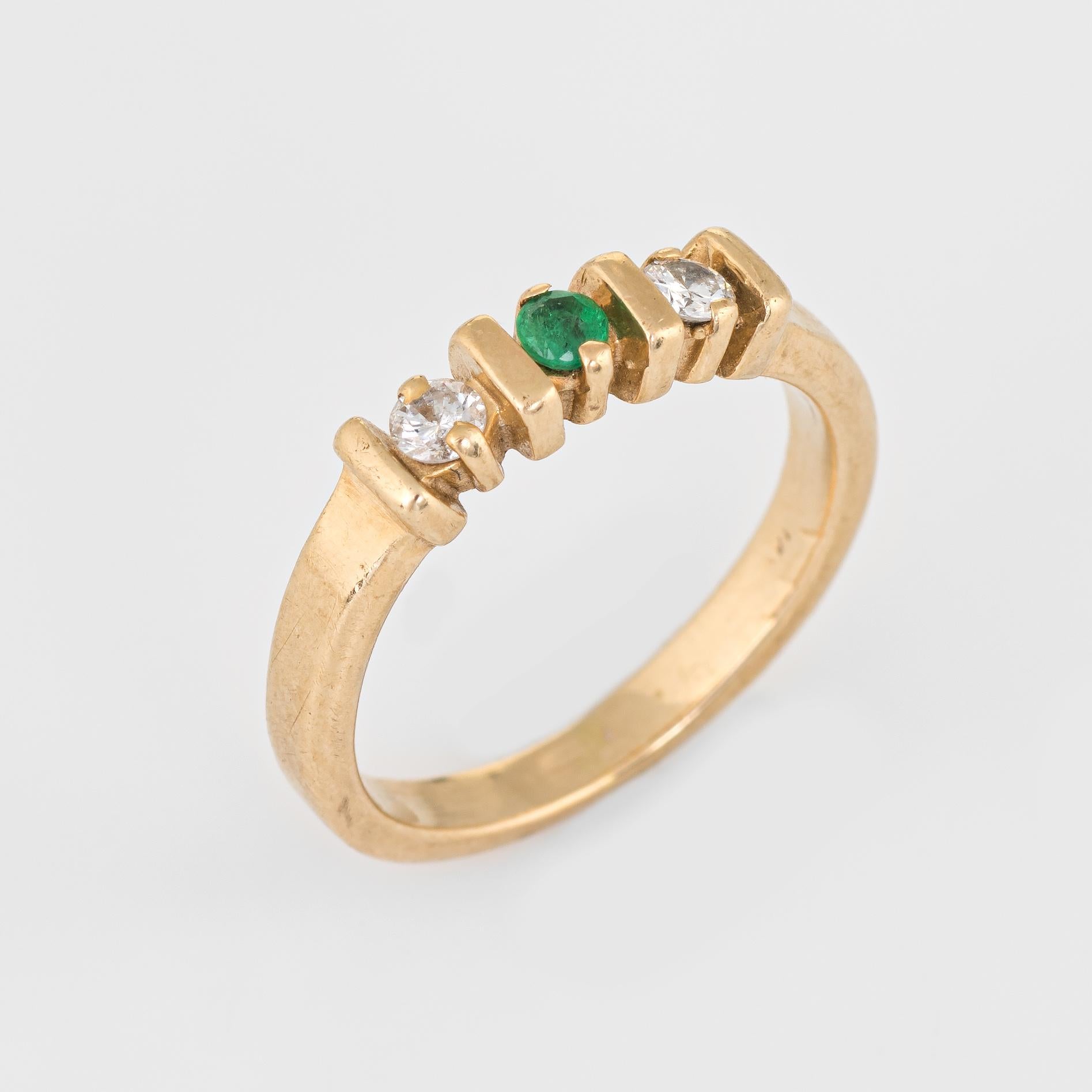 Stylish vintage emerald & diamond band crafted in 14 karat yellow gold. 

Centrally mounted emerald is estimated at 0.05 carats, accented with two estimated 0.05 carat diamonds. The total diamond weight is estimated at 0.10 carats (estimated at I