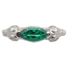 Anello a fascia in platino con diamante smeraldo