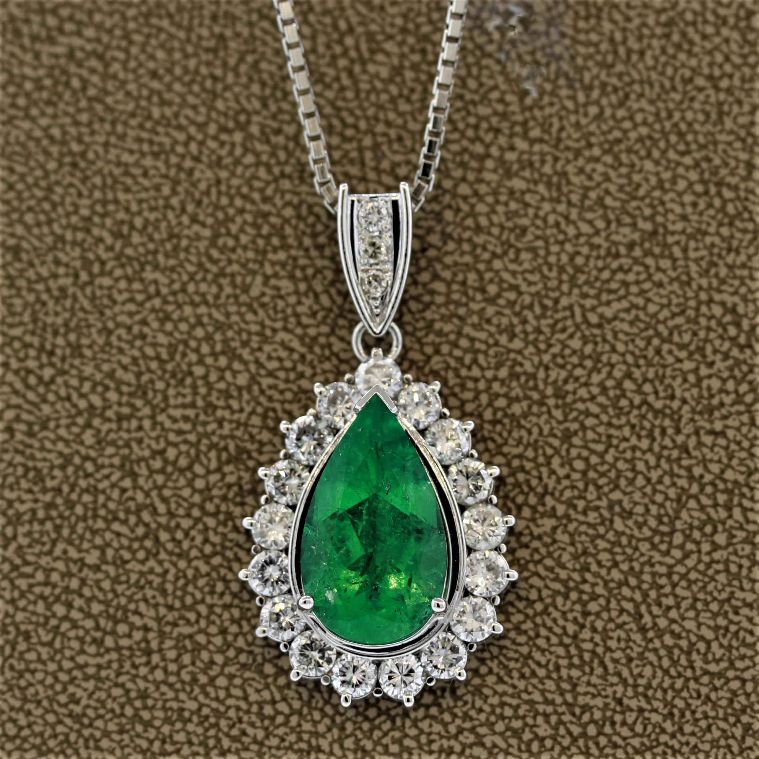 A large pear-shaped emerald takes center stage on this platinum pendant. The emerald weighs 8.30 carats and has a pleasant green color typical of Colombian emeralds. It is haloed by 3.12 carats of large round brilliant cut diamonds along with 3