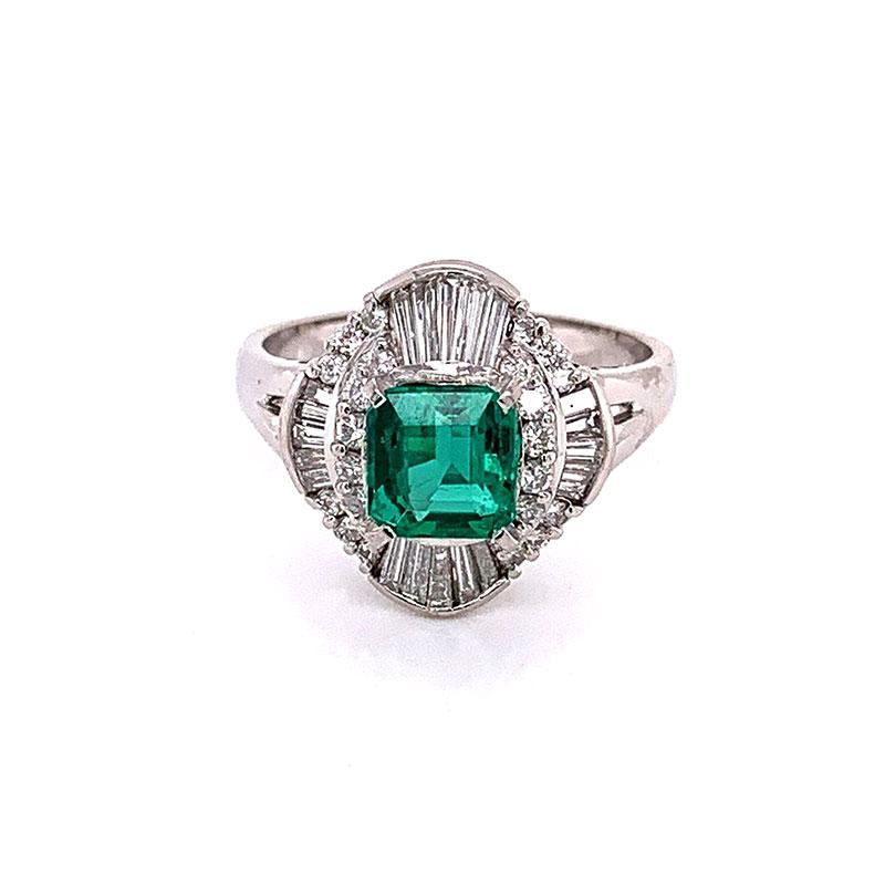A lovely platinum hand-fabricated ring featuring a 1.37 carat emerald with a vivid green color and excellent brilliance. It is accented with 0.90 carats of round brilliant and baguette cut diamonds set in a geometric pattern. A superb gemstone and a