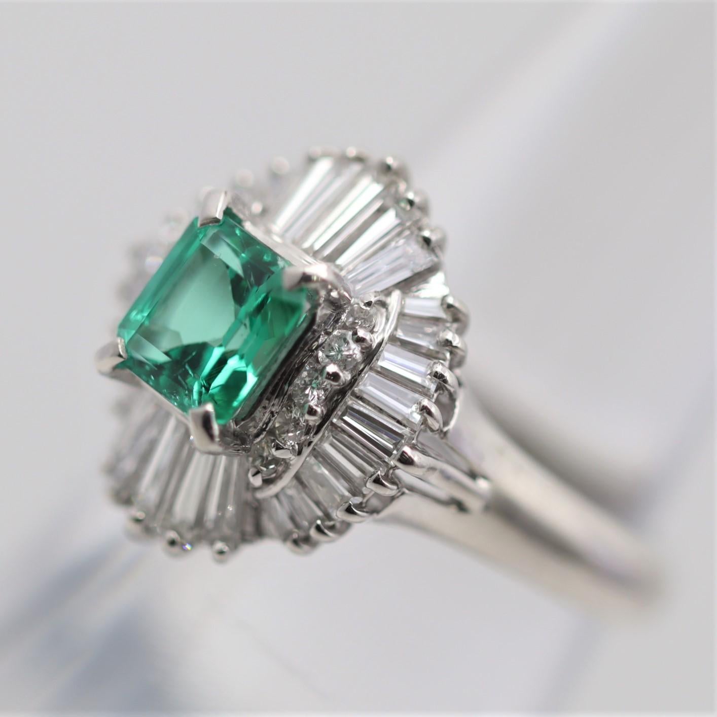 A simple yet elegant platinum ring featuring a 0.86 carats emerald-cut emerald with a vibrant bright green color. It is accented by 0.99 carats of bright white diamonds surrounding the emerald in a stylish pattern. Hand-fabricated in platinum and