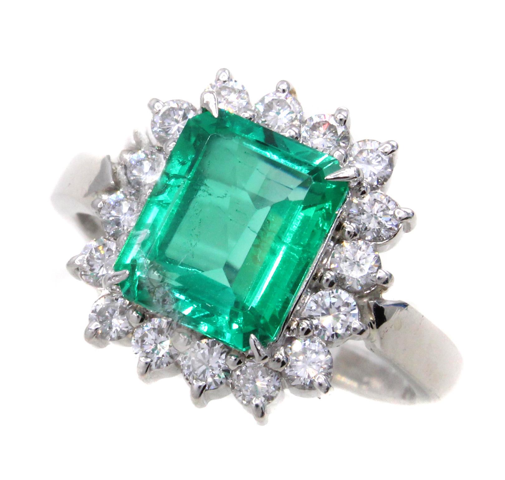 A beautifully laid out vivid green natural emerald weighing 1.99 carats is the center-piece of this impressive ring. The emerald is very clean and has very few natural inclusions. Well cut with perfect proportions this emerald shows a much larger