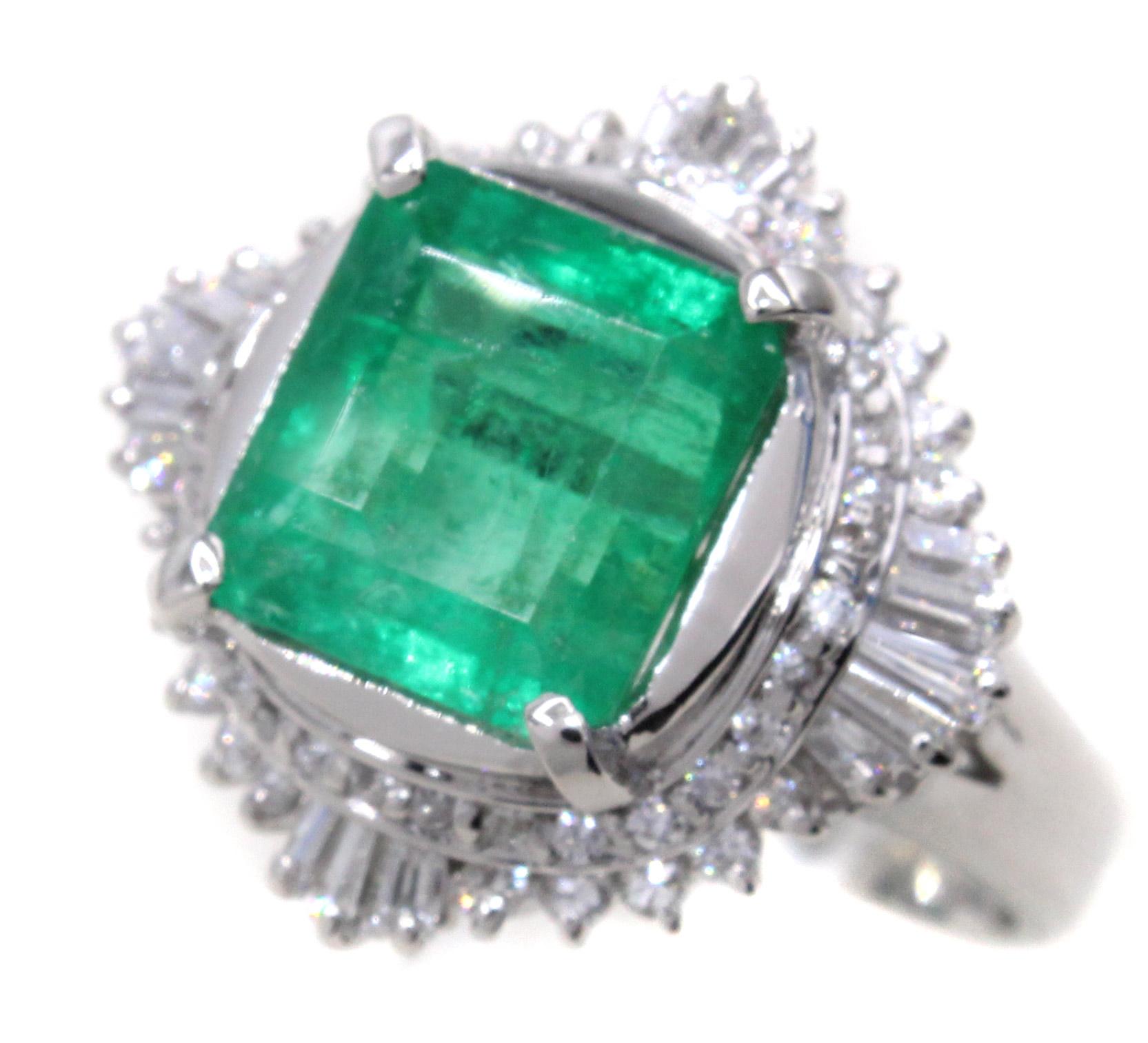 A square cut forest green emerald is the center piece of this beautiful and well hand-crafted 1970s ring. The emerald has been measured to weigh approximately 3.85 carats and is surrounded by a wavy gallery of white bright round brilliant cut and