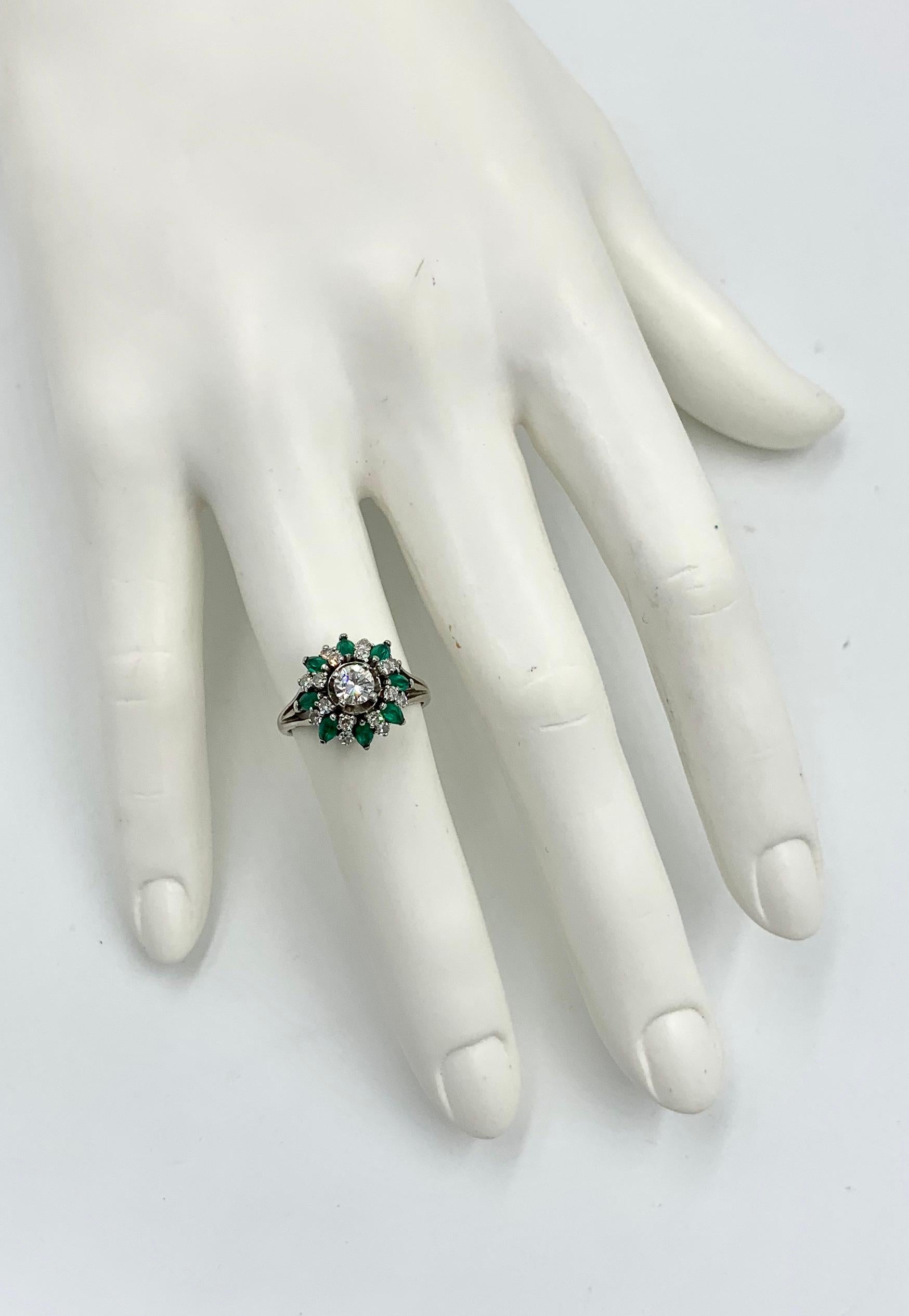 A stunning antique Diamond Emerald bombe cluster Ring.  The ring features a central Round Brilliant Cut Diamond of .34 Carats. This gorgeous diamond is surrounded by 16 sparkling round diamonds.  The diamonds are H-I color, very white and just