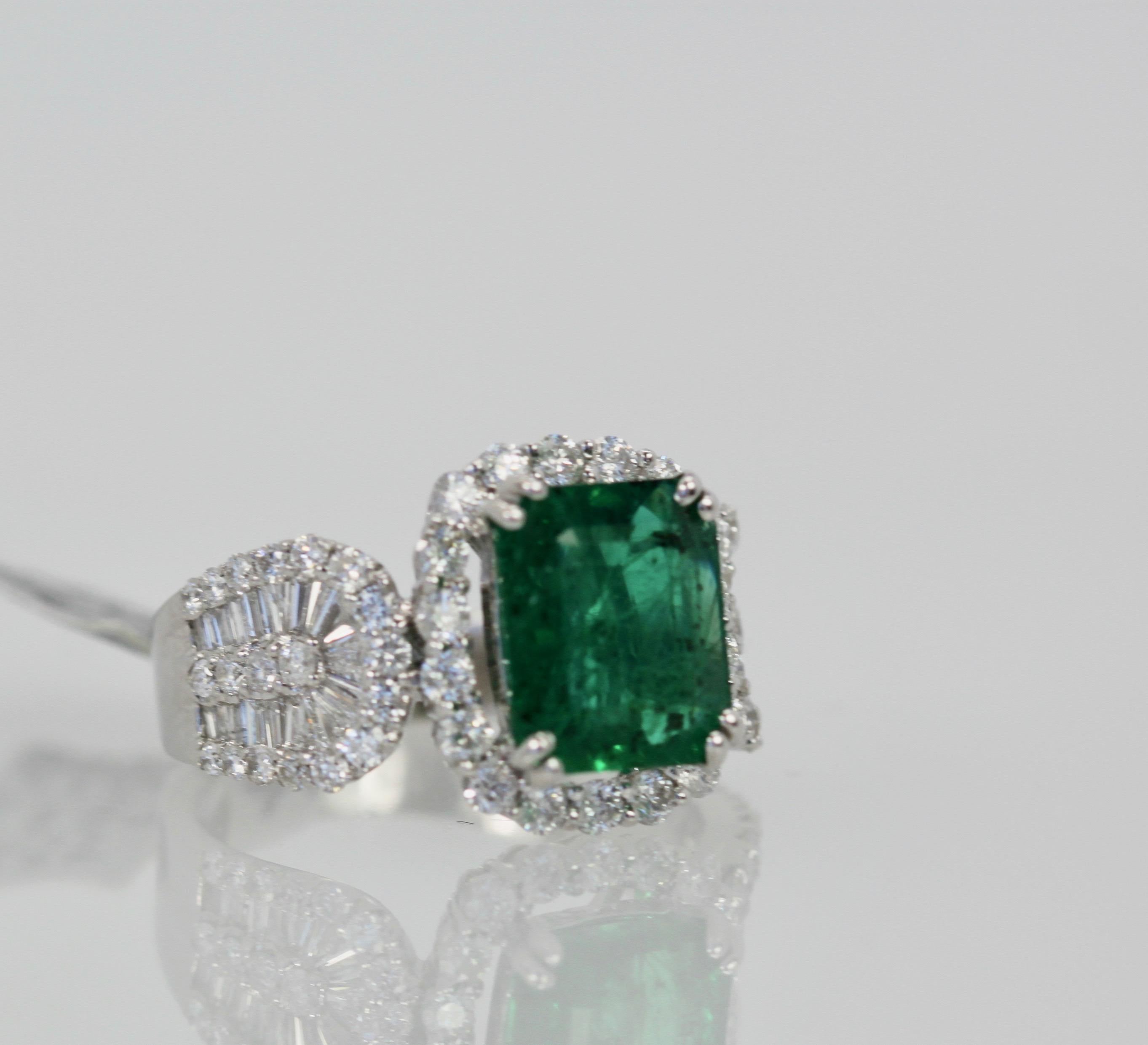 This Emerald Diamond Ring is new and never been worn.  It is a gorgeous true emerald green and without magnification is absolutely clean to the eye.  As most Emeralds have inclusions and dark spots so does this ring but without magnification it is
