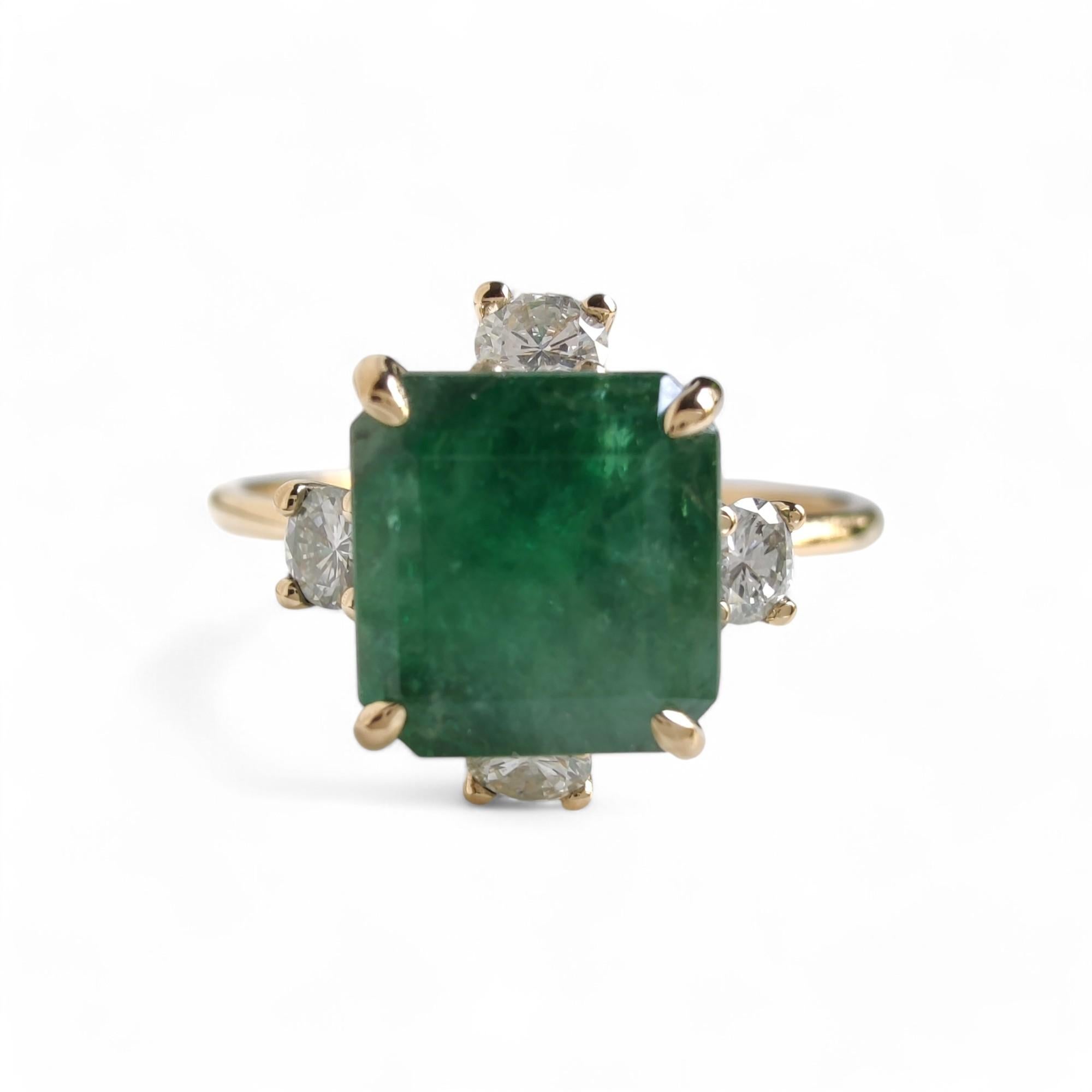 Anillo de diseño único inspirado en la naturaleza, con una esmeralda coronada por cuatro diamantes que asemejan flores floreciendo al amanecer. Anillo artesanal para mujer, ideal para las amantes de la naturaleza, que simboliza la elegancia y la