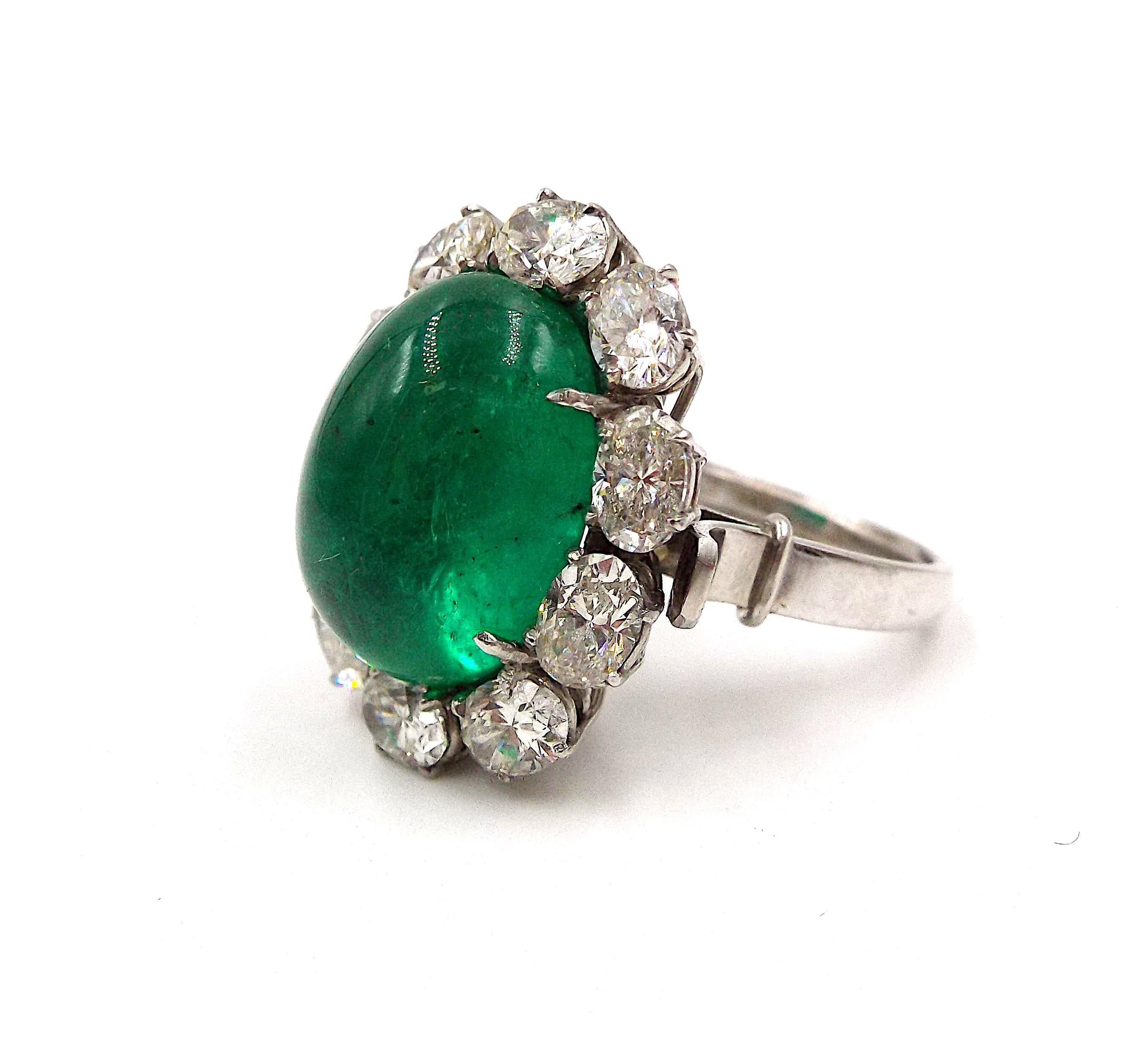 An elegant ring featuring a cabochon emerald weighing 11.88ct, surrounded by oval diamonds approx. 3ct in total. Ring US size 4.75, sizeable (inner horseshoe). Weight 12.7 grams.