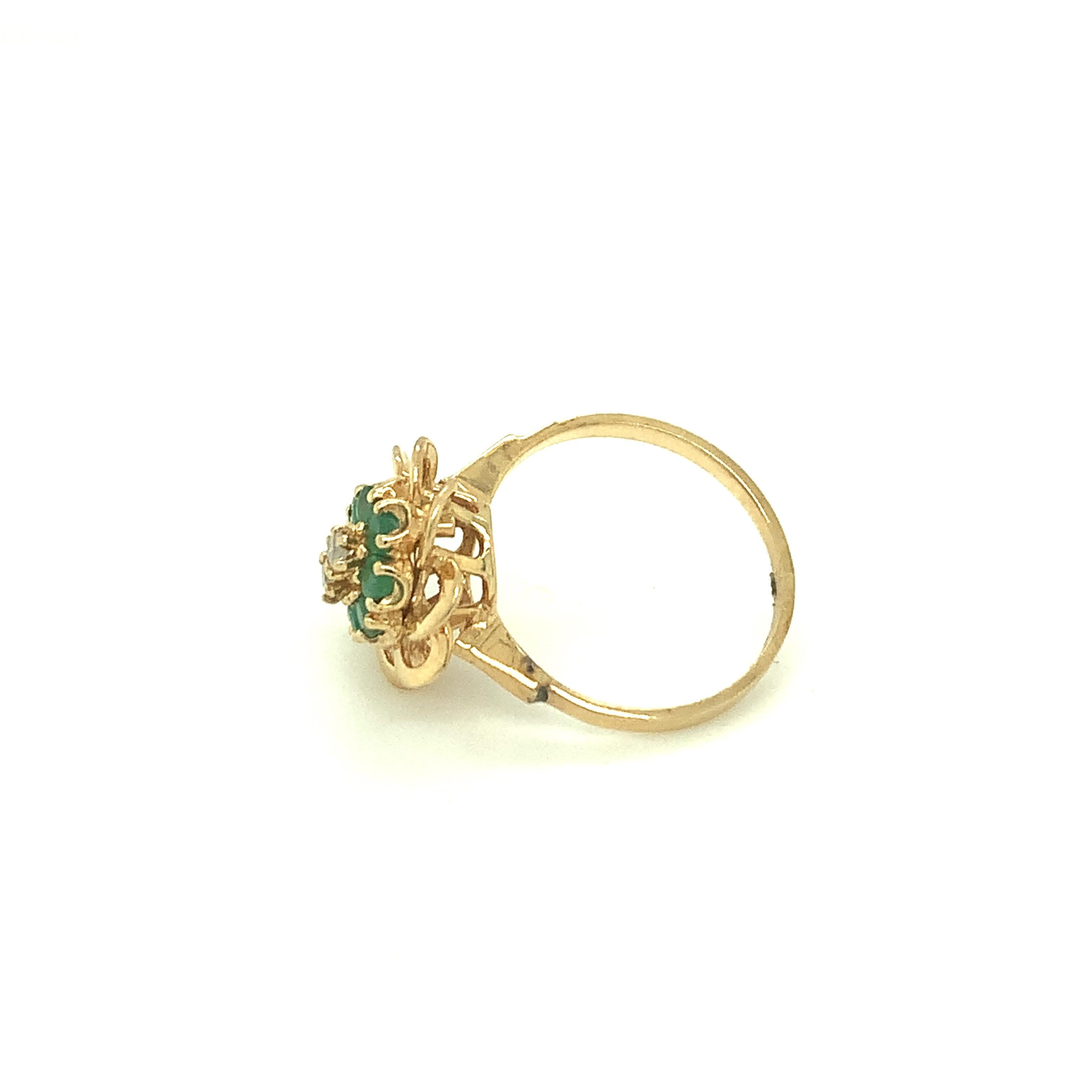 A classic beauty of yesteryear, this floral inspired ring has emerald with diamond in center set in 14K yellow gold.
