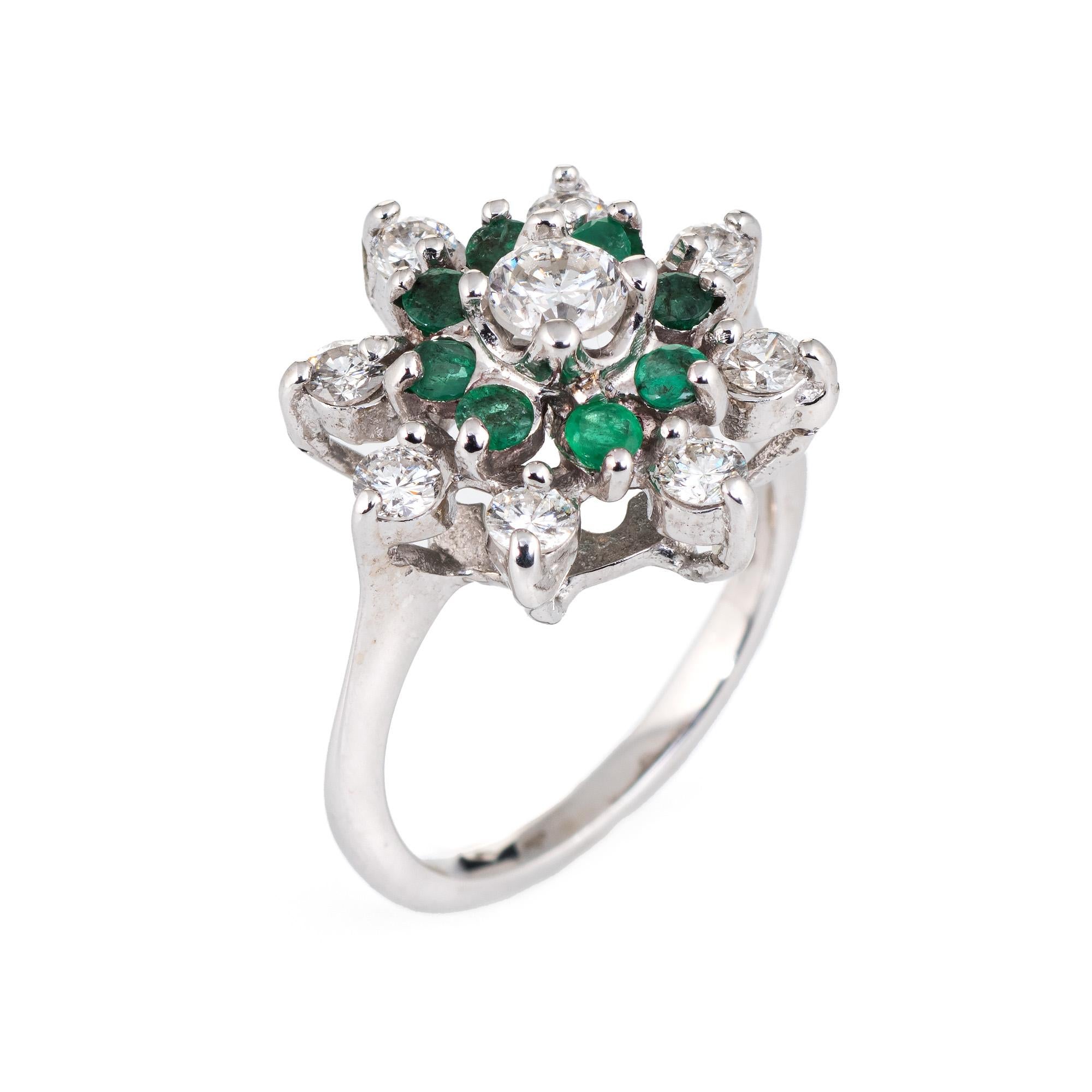 Elegant vintage emerald & diamond ring (circa 1960s to 1970s), crafted in 14 karat white gold. 

Centrally mounted round brilliant cut diamond is estimated at 0.25 carats, accented with a further 8 estimated 0.05 carat diamonds. The total diamond