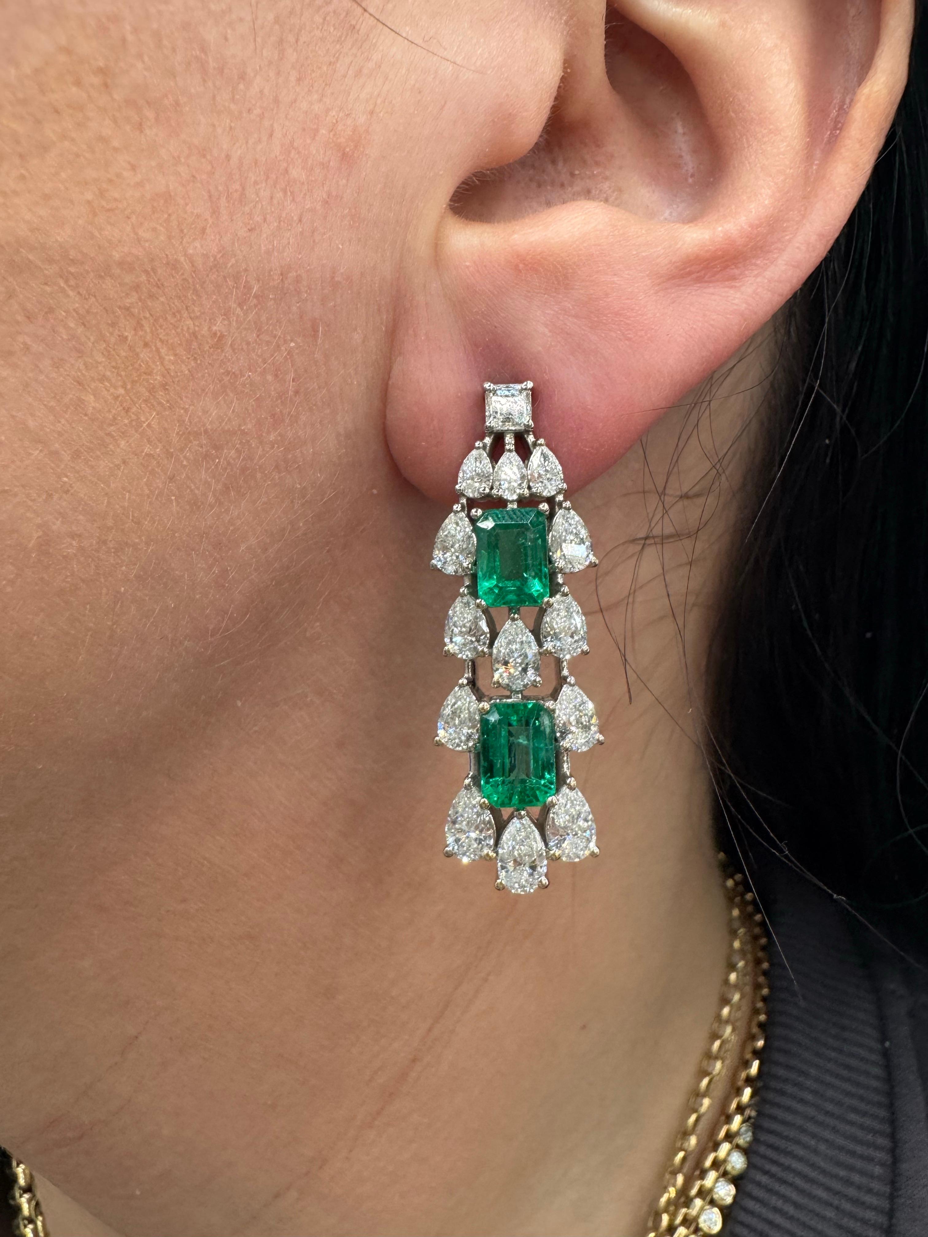 Éblouissantes d'élégance et de sophistication, ces boucles d'oreilles exquises sont ornées d'un total de 7,15 carats d'émeraudes en taille émeraude richement saturées. Chaque pierre précieuse d'un vert éclatant est magnifiquement encadrée par des