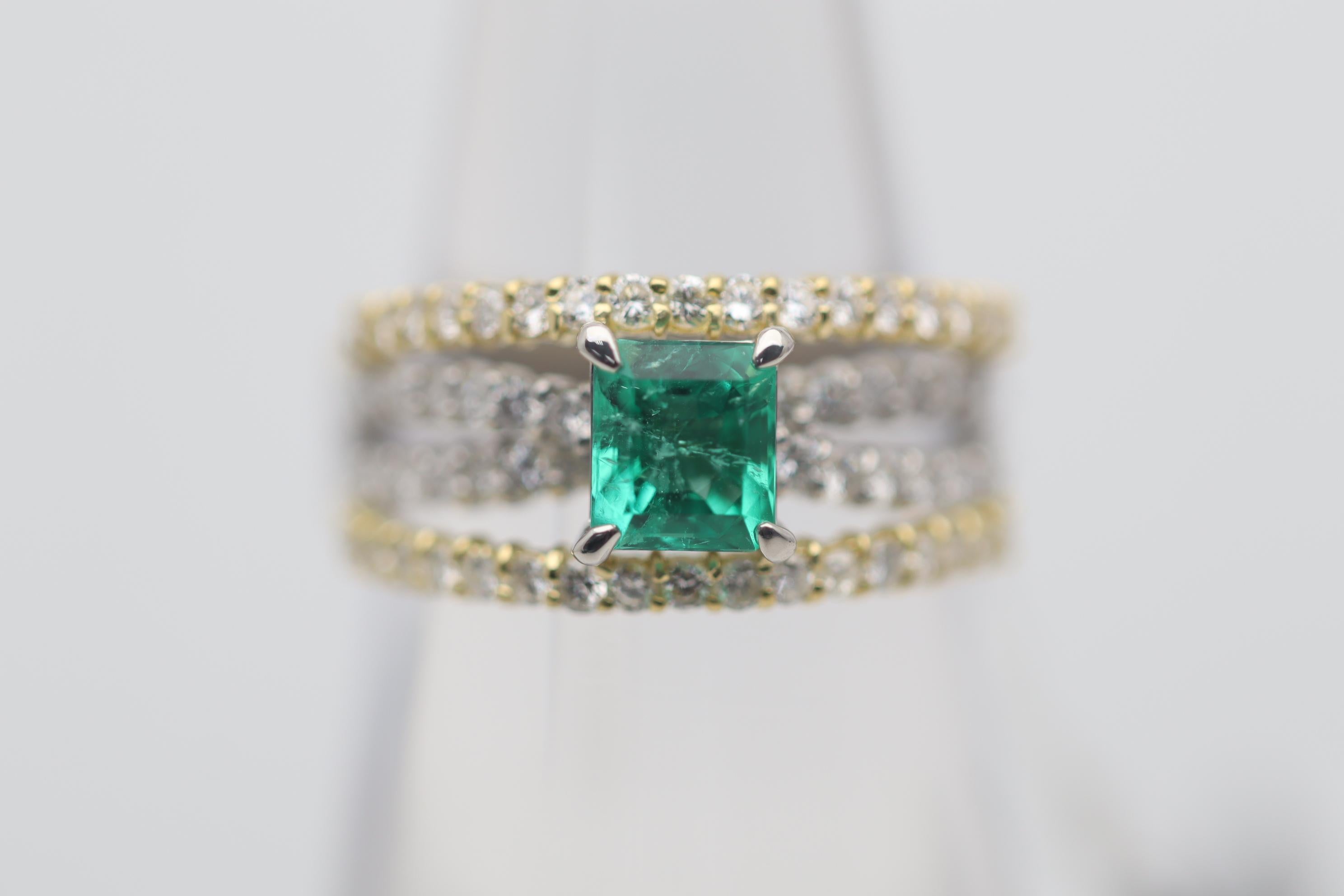 A sleek and stylish ring featuring a fine gem quality emerald weighing 0.77 carats. It has a rich ideal bright grass green color that makes emerald the top green colored gemstone. It is complemented by 0.78 carats of round brilliant-cut diamonds set