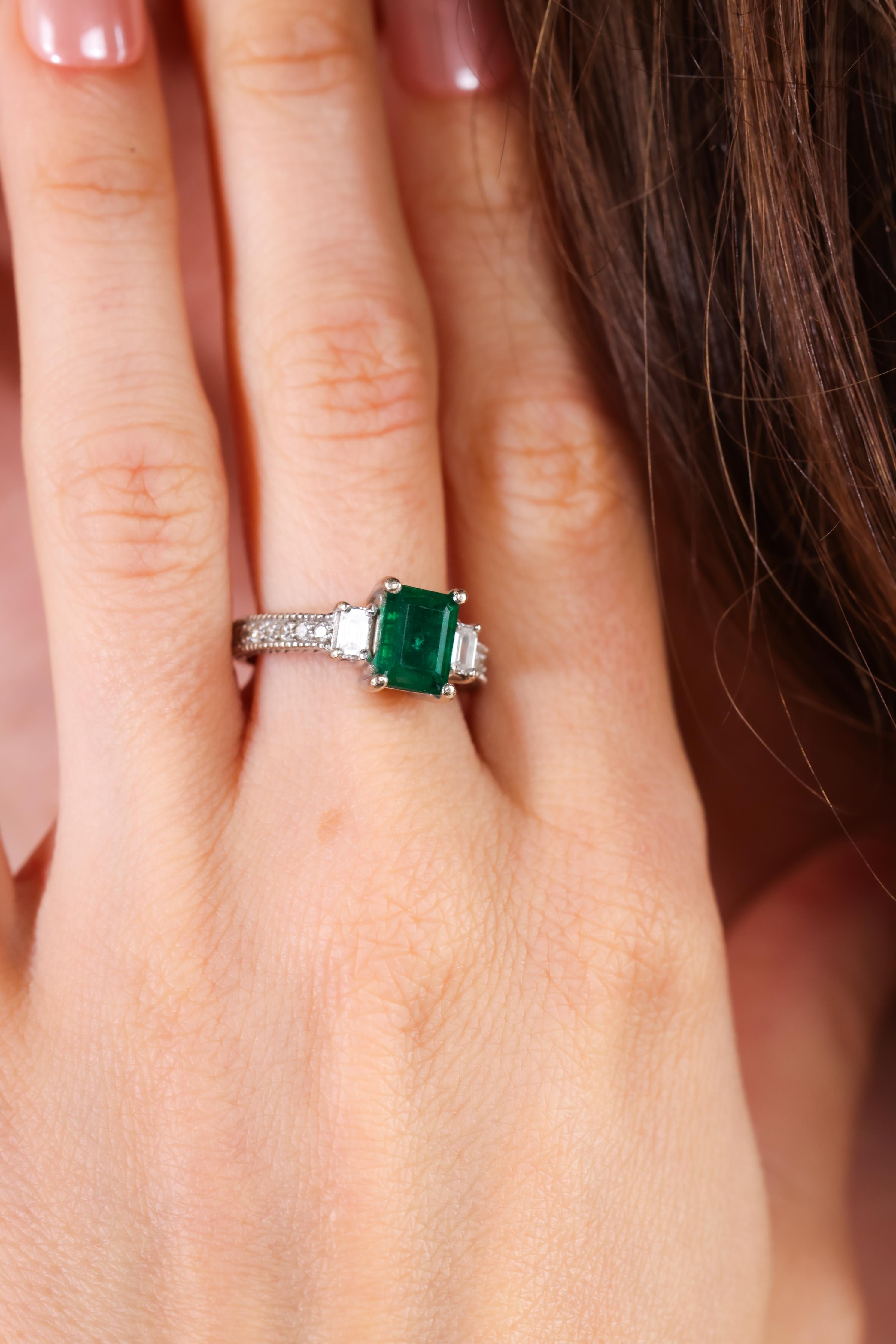 Center Stone: Emerald
Cut: Emerald
Weight: 1.50 carats approximately 
Accent Stone: 12 diamonds 
Cut: Emerald and round brilliant 
Weight: 0.45 carats approximately 
Color: G-H 
Clarity: VS
Metal: 14k white gold
Circa: 1990s 
Size: 6-1/2 and can be