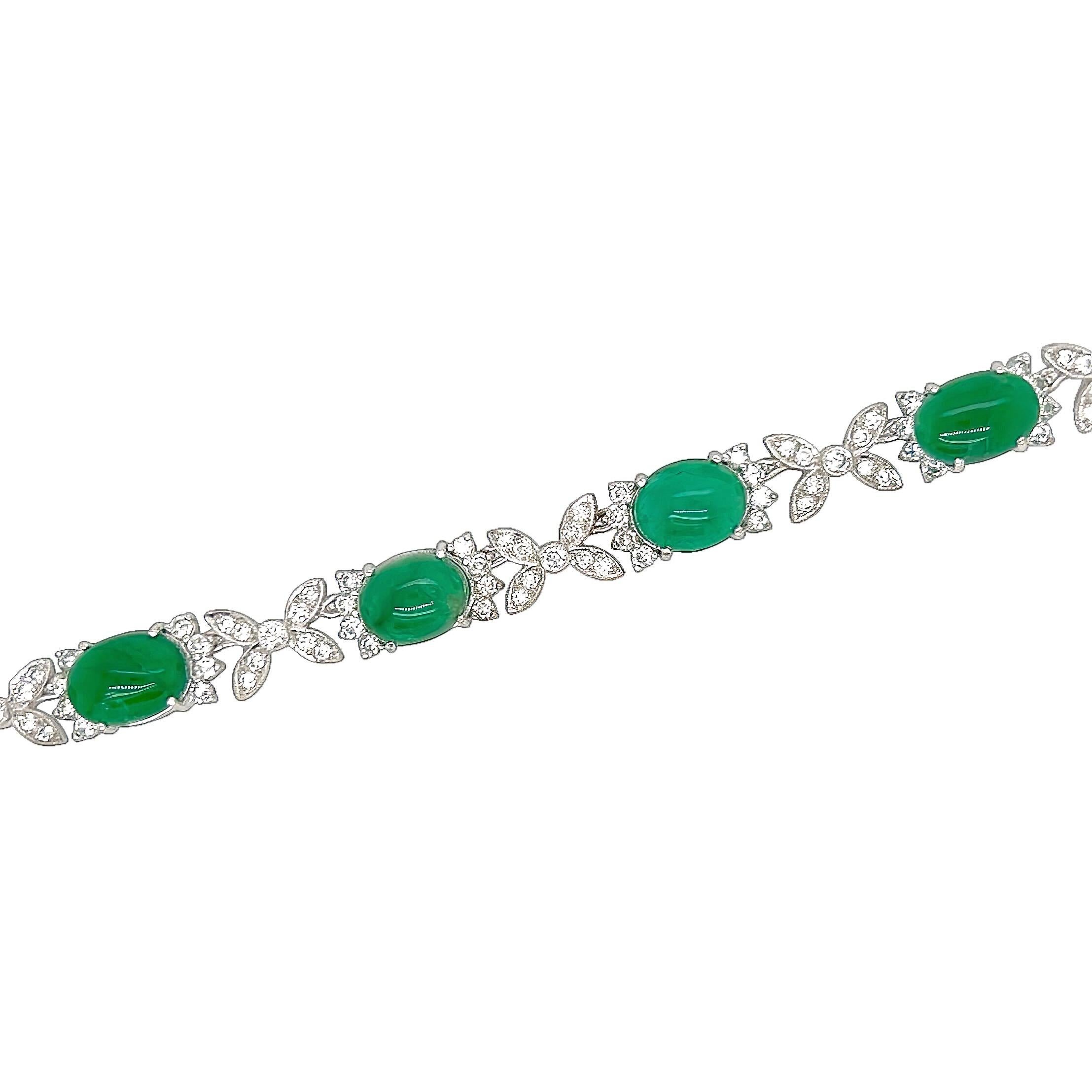 Una collana in oro bianco, smeraldi e diamanti.  Disegnato come una lunghezza di 16 smeraldi ovali cabochon, circondati da otto diamanti rotondi taglio brillante ciascuno e alternati a motivi a X con incastonati altri 318 diamanti rotondi taglio