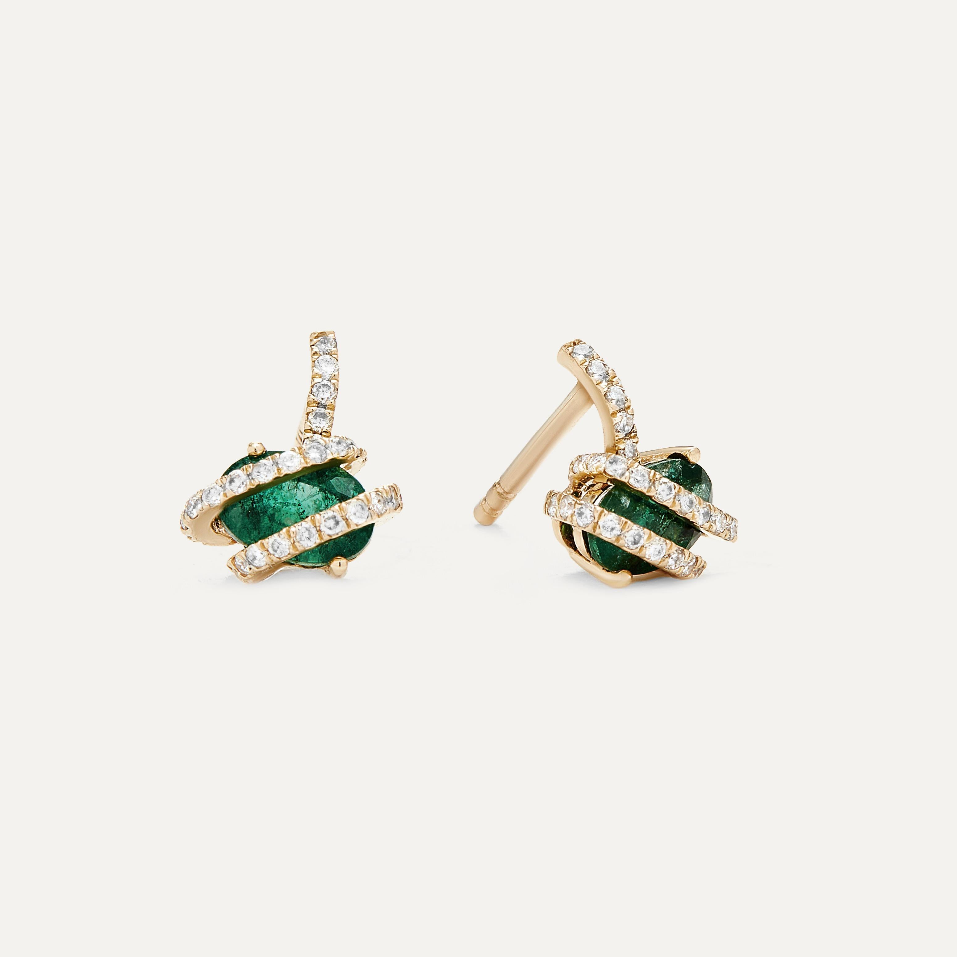 The Emerald Diamond Wrap Studs are a remarkable embodiment of elegance and sophistication. These stud earrings feature a unique and captivating design, where a vivid green oval emerald is cradled by a wrap of exquisite white diamonds. The emerald's