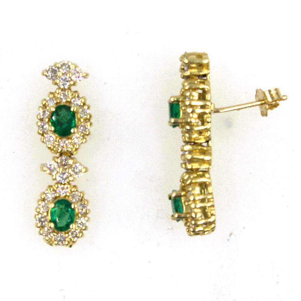 An estate pair of emerald and diamond earrings. The earrings feature 4 oval cut emeralds (1.04 carat total weight) surrounded by 28 round brilliant cut diamonds (1.28 carat total weight). The drops measures 1.0 inch in length and .30 inches in