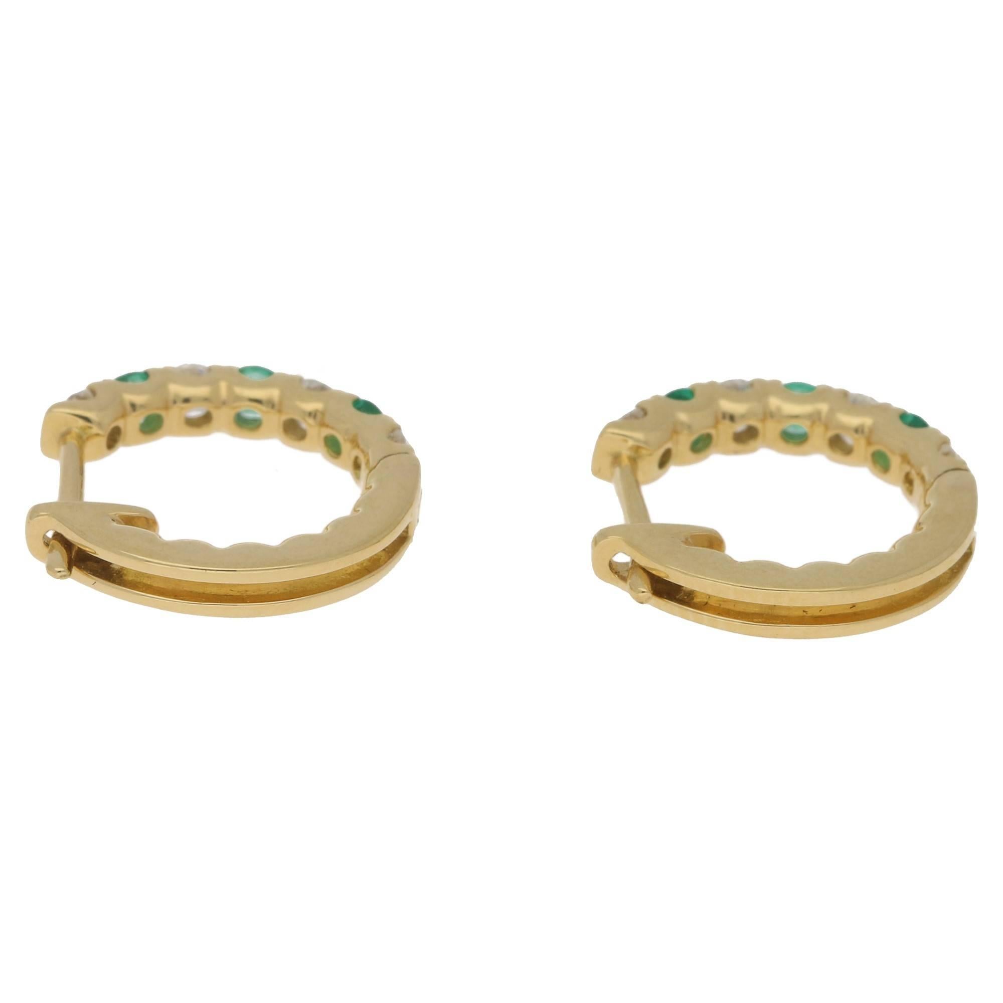 Containing 0.36ct's emerald and 0.22ct's diamond, G/H colour and VS clarity. 
These vibrant emerald and diamond hoop earrings are set onn simple click shut fittings, the earrings are detailed with the stone weights, and the gold karat.