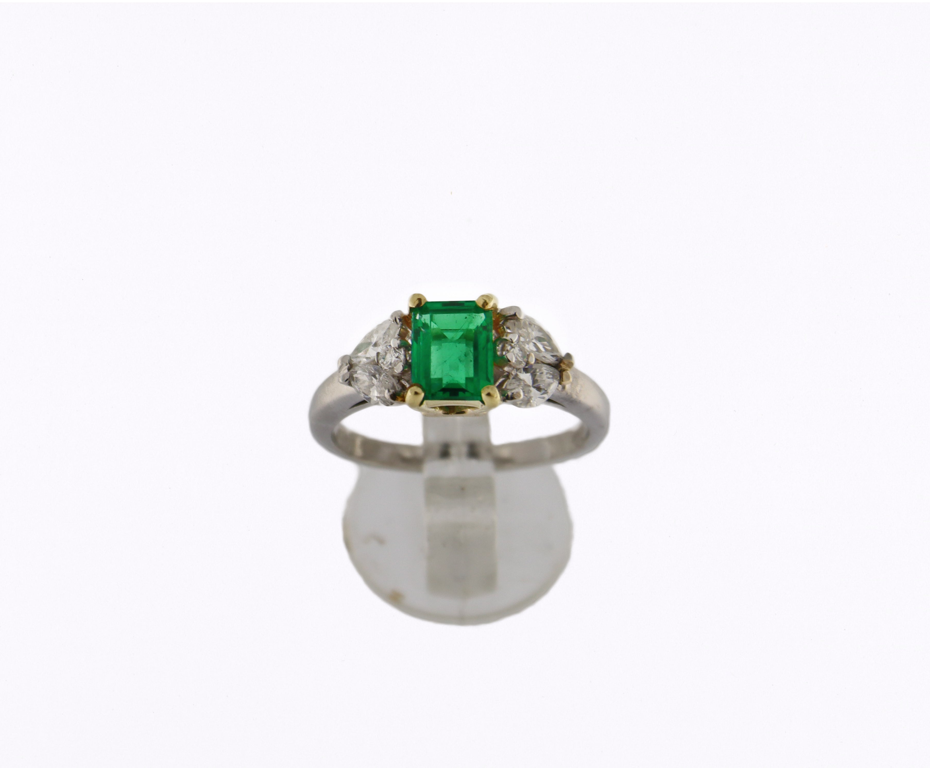 Dieser aus 18 Karat Weißgold gefertigte Ring ist ein Meisterwerk von außergewöhnlicher Schönheit, das klassische Eleganz mit zeitlosem Luxus verbindet. Im Zentrum der Fassung liegt ein atemberaubender natürlicher Smaragd, der sich durch seine