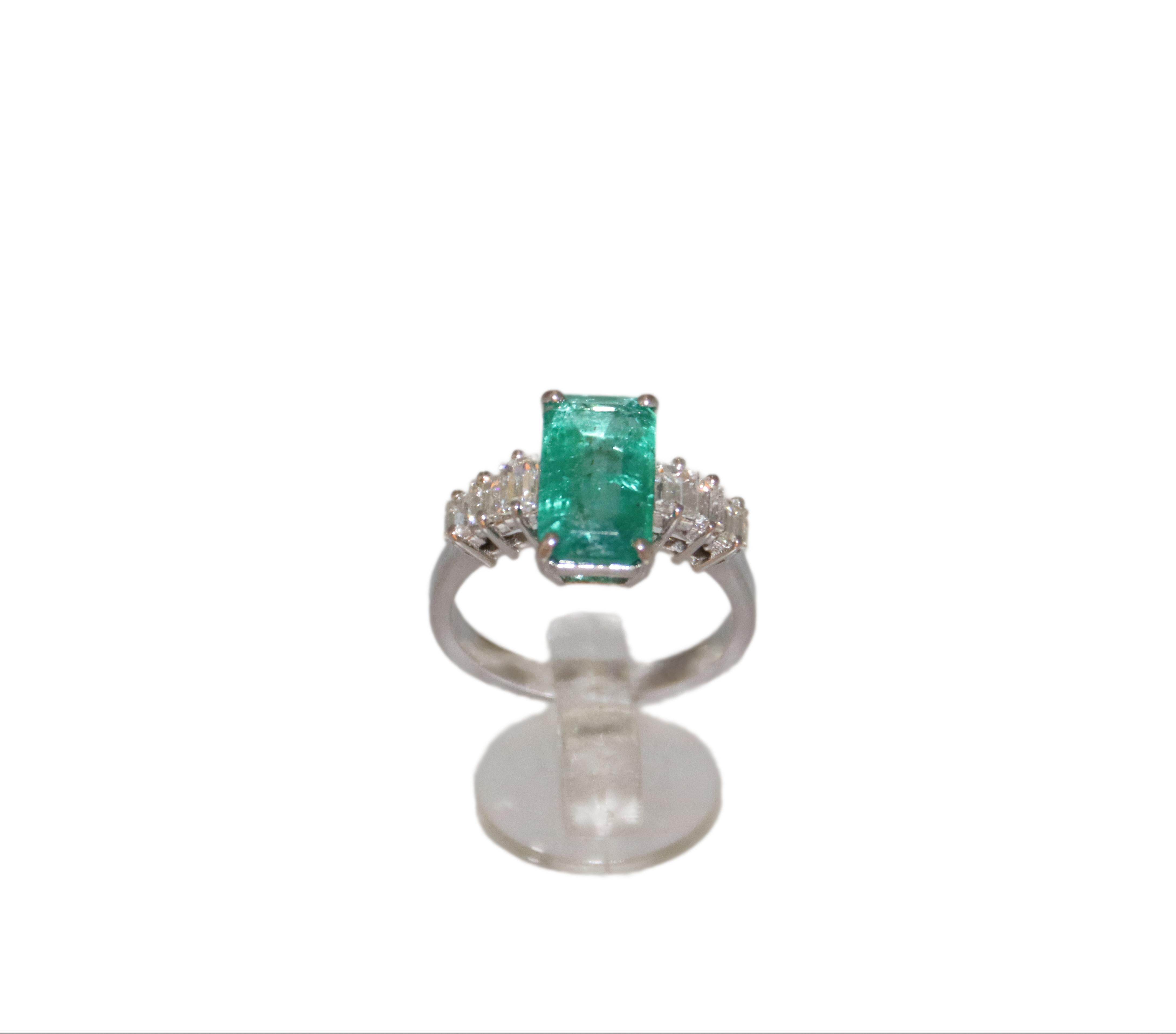A masterpiece of elegance and refinement, this stunning 18K white gold ring is a true celebration of luxury and timeless beauty. The undisputed star of this jewel is a beautiful central emerald, with a rectangular cut, captivating the eye with its