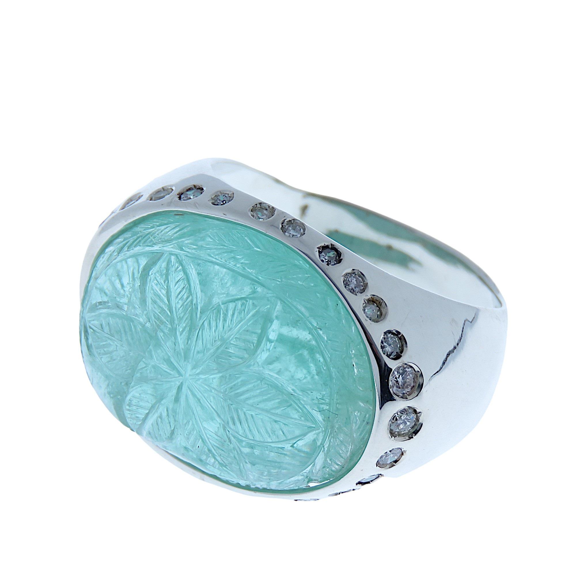 Dome ring showcasing an extraordinary carved emerald with floral motifs set in 9 karat white gold with 26 brilliant cut white diamonds. US finger size is 8 , French size 57, Italian size 17, the ring can be resized to the customer's size before
