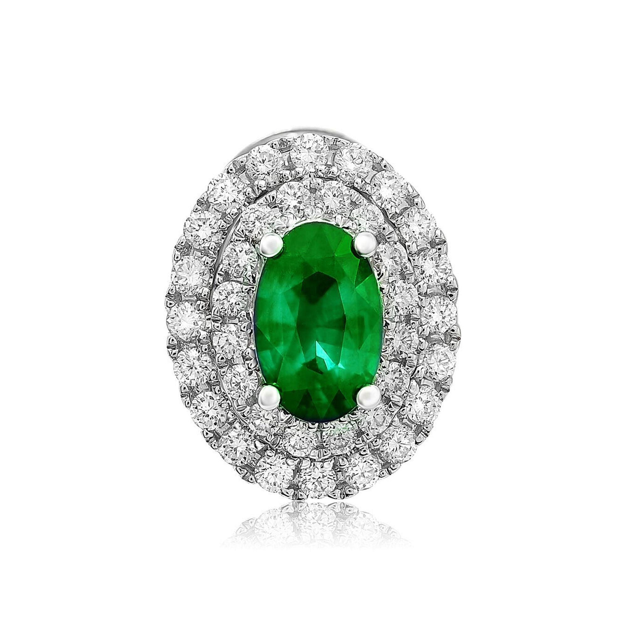 At the center of these eye-catching 18 karat white gold stud earrings rest 0.96 carats of brilliant oval cut emeralds. A sparkling double halo of white diamonds surrounds each center stone with a total weight of 0.50 carats of round cut white