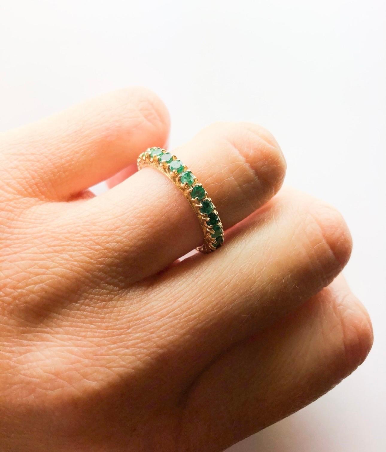 Emerald eternity ring in size 6, can be re-sized. The emeralds are a vivid green color made in a unique U cut setting style that shows off the gemstones all around. Emeralds totaling 2 carats with slightly included clarity and green