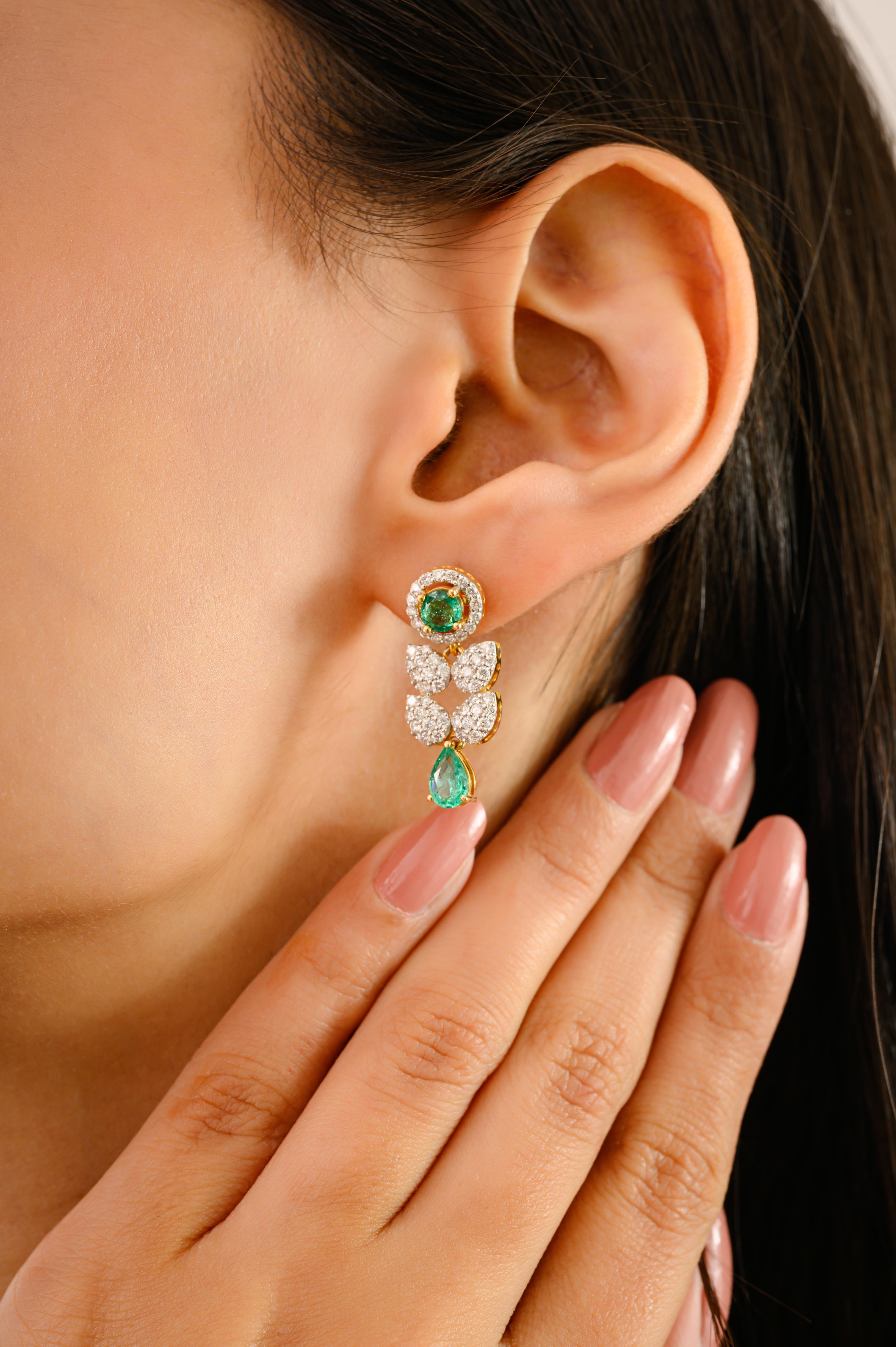 Eleva tu elegancia con estos cautivadores pendientes colgantes de oro amarillo de 14k, diseñados para hacer una declaración de lujo refinado. Con un total de 1,65 quilates de vibrantes esmeraldas verdes -incluidas en talla pera y redonda-, cada gema