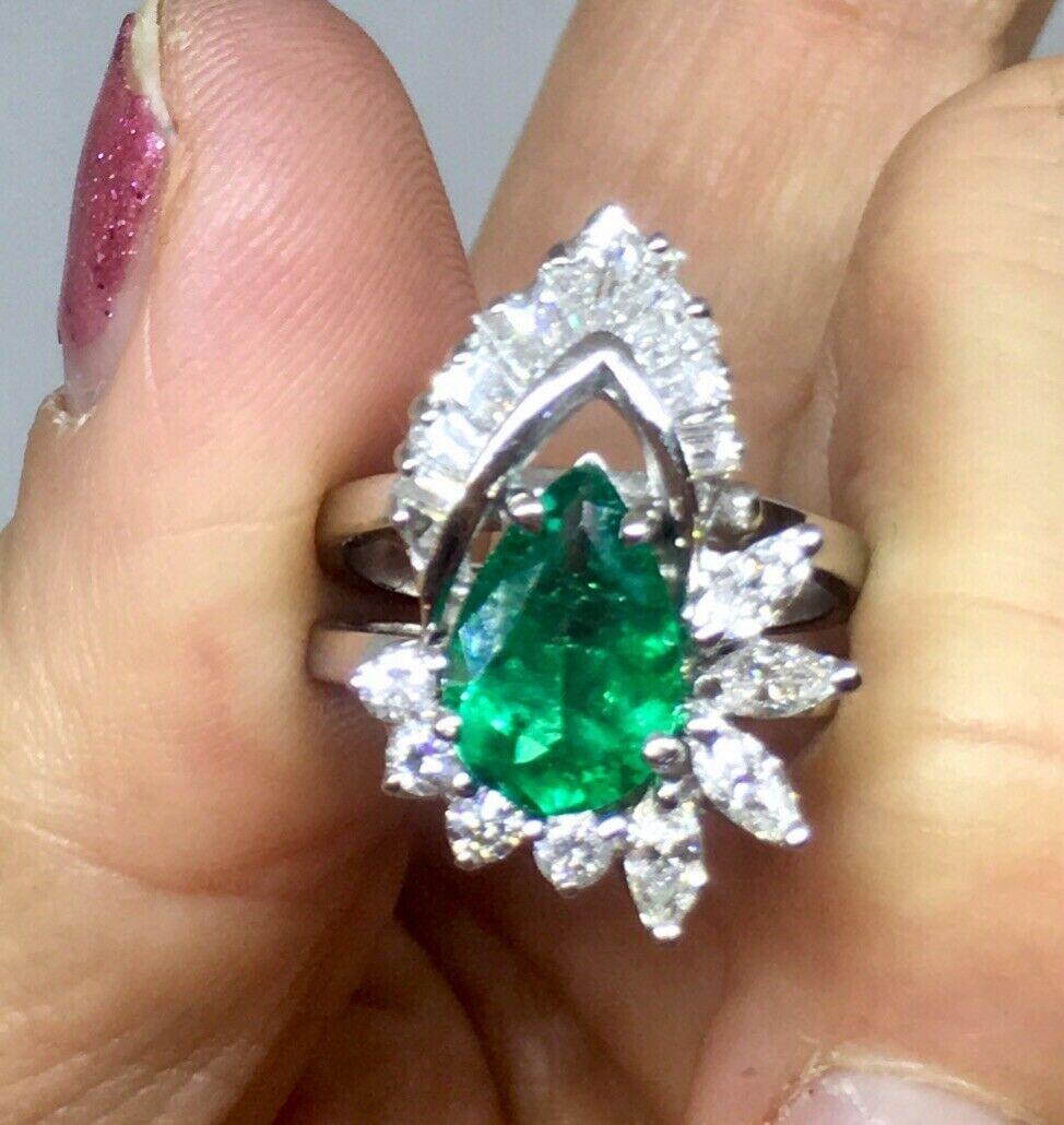 This beautiful midcentury estate ring is set with a beautiful lively green pear shaped emerald that measures approximately 2.00 carats (11 X 8 X 4.5 mm).  The ring is also surrounded by a total of 17 diamonds, totaling approximately 1.00 carats,