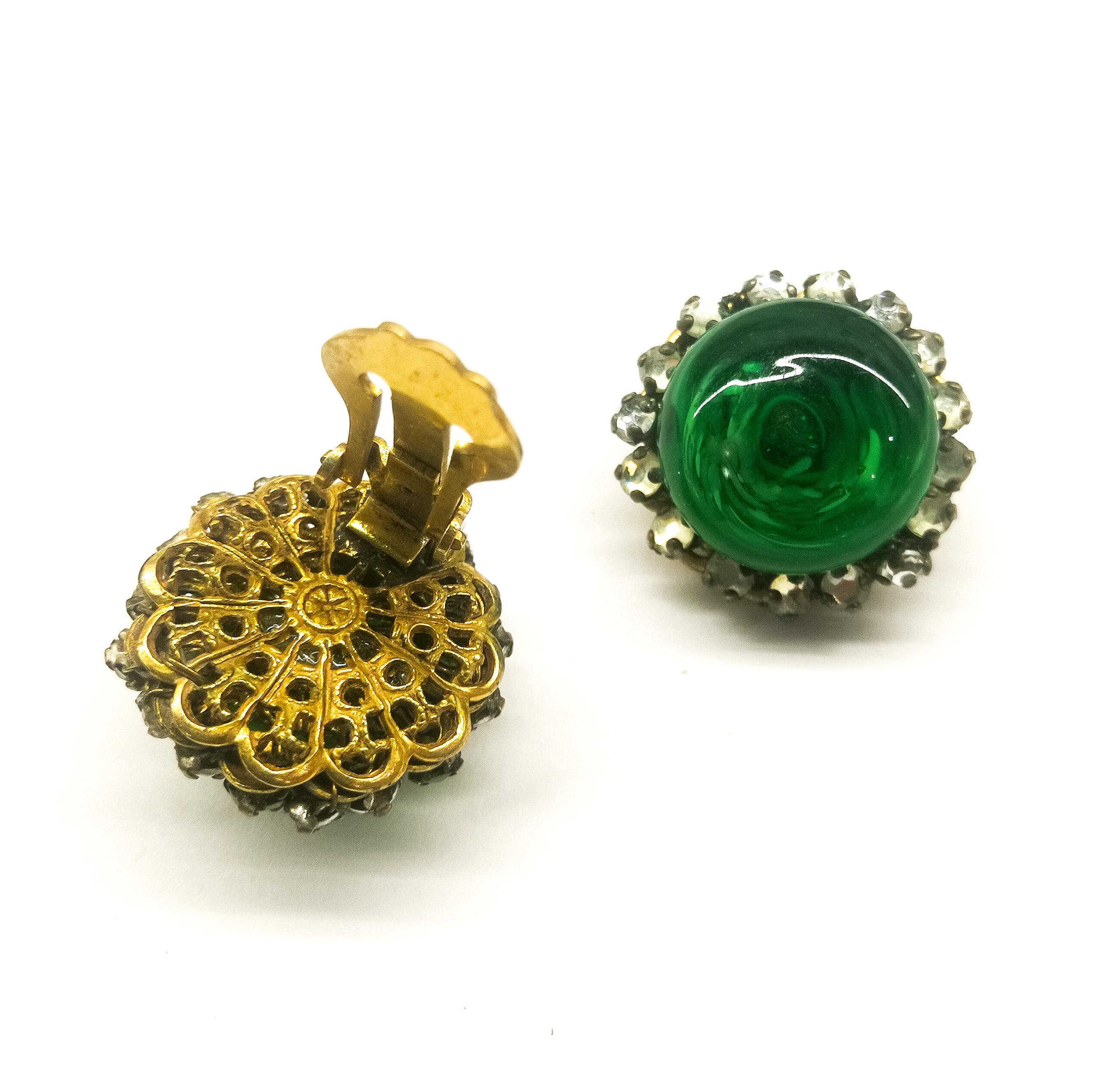 A very beautiful, simple but very wearbable pair of emerald earrings, with a deep emerald glass centre stone/button, with faux inclusions. Surrounded by a single row of clear paste rose montes stones, with a filigree antiqued gilt metal backing,