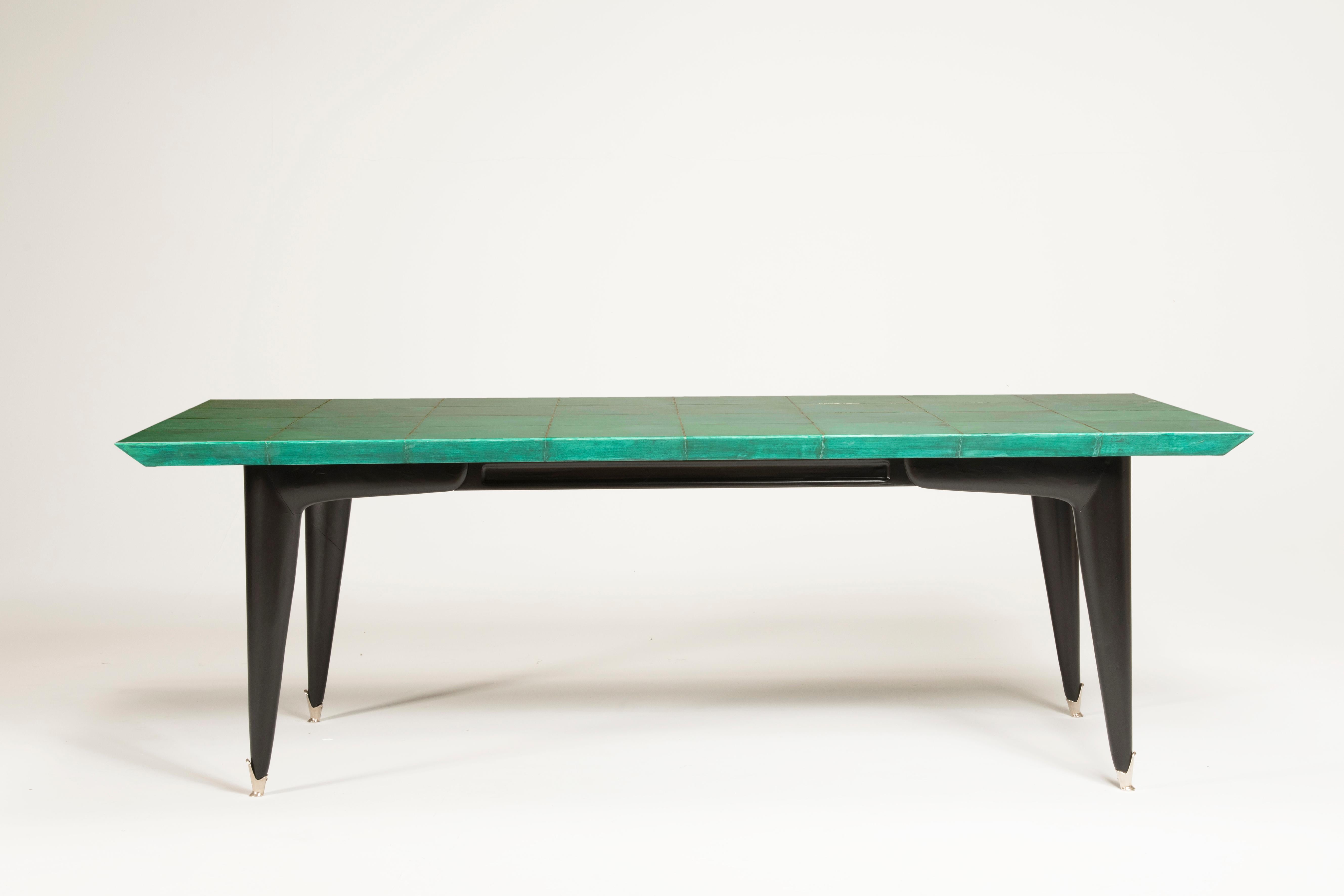 Rectangular table with top made of Emerald goatskin paneled with silver nichel metal lines. The kind of goatskin and its color are typical of Aldo Tura works. Size of the table: L 220 x D 120 x H 72 cm. Legs are black lacquered with silver nichel