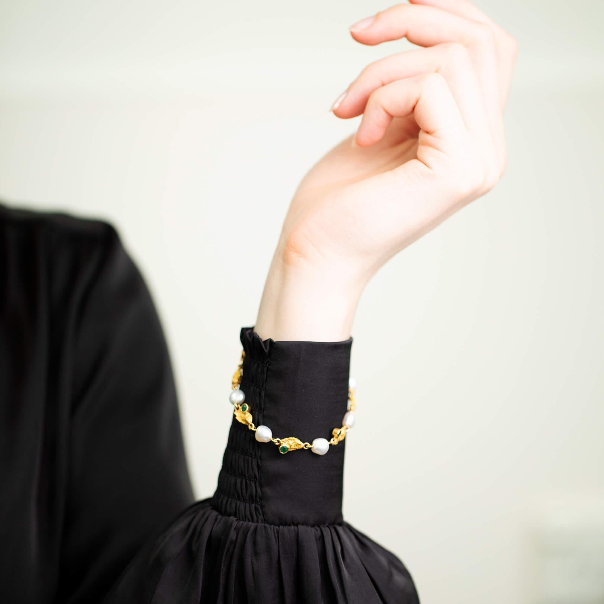 Dieses einzigartige, moderne Armband besteht aus acht Goldnuggets, von denen vier mit natürlichen grünen Smaragden besetzt sind. Zwischen jedem Goldnugget befindet sich eine Keshi-Perle, die das Armband als Ganzes verbindet. Mit einer goldenen