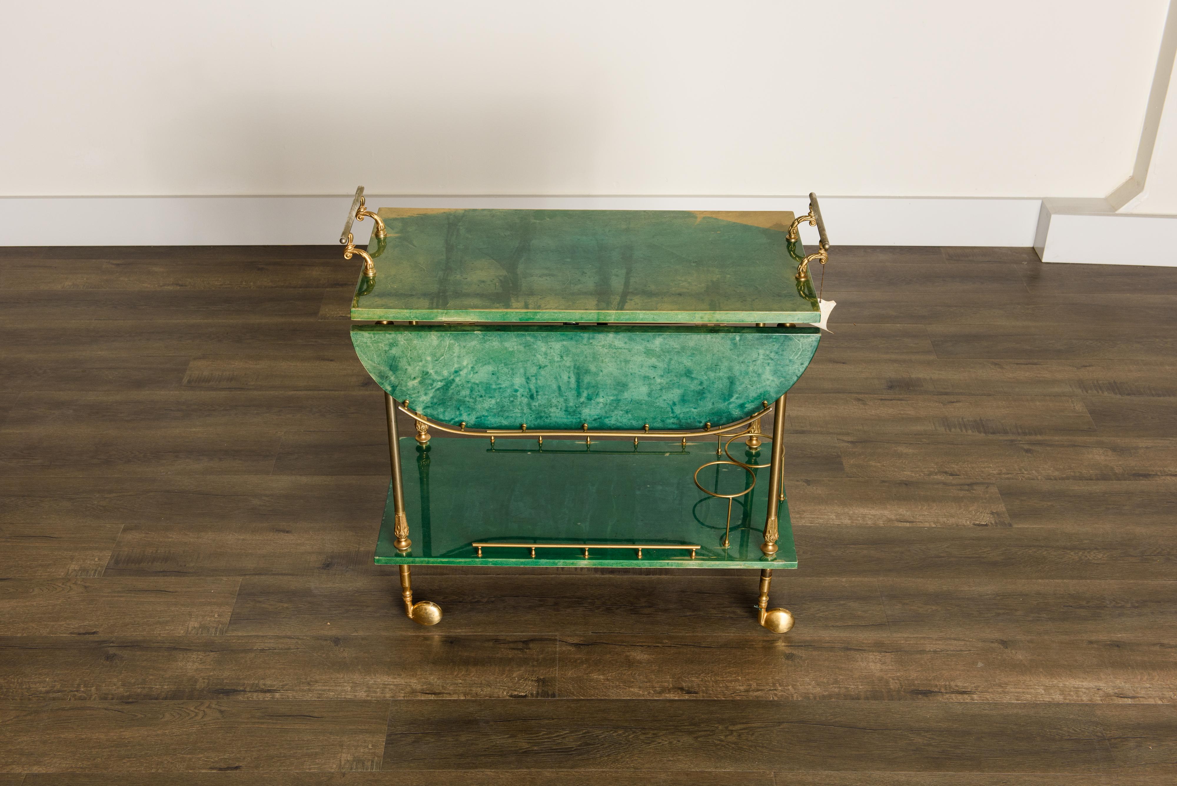 Beautiful emerald green bar cart by Italian artist-craftsman Aldo Tura, featuring the designers distinct use of brass and lacquered goatskin that Tura was well-known for. The quality of Aldo Tura's craftsmanship is due to the fact that his work was