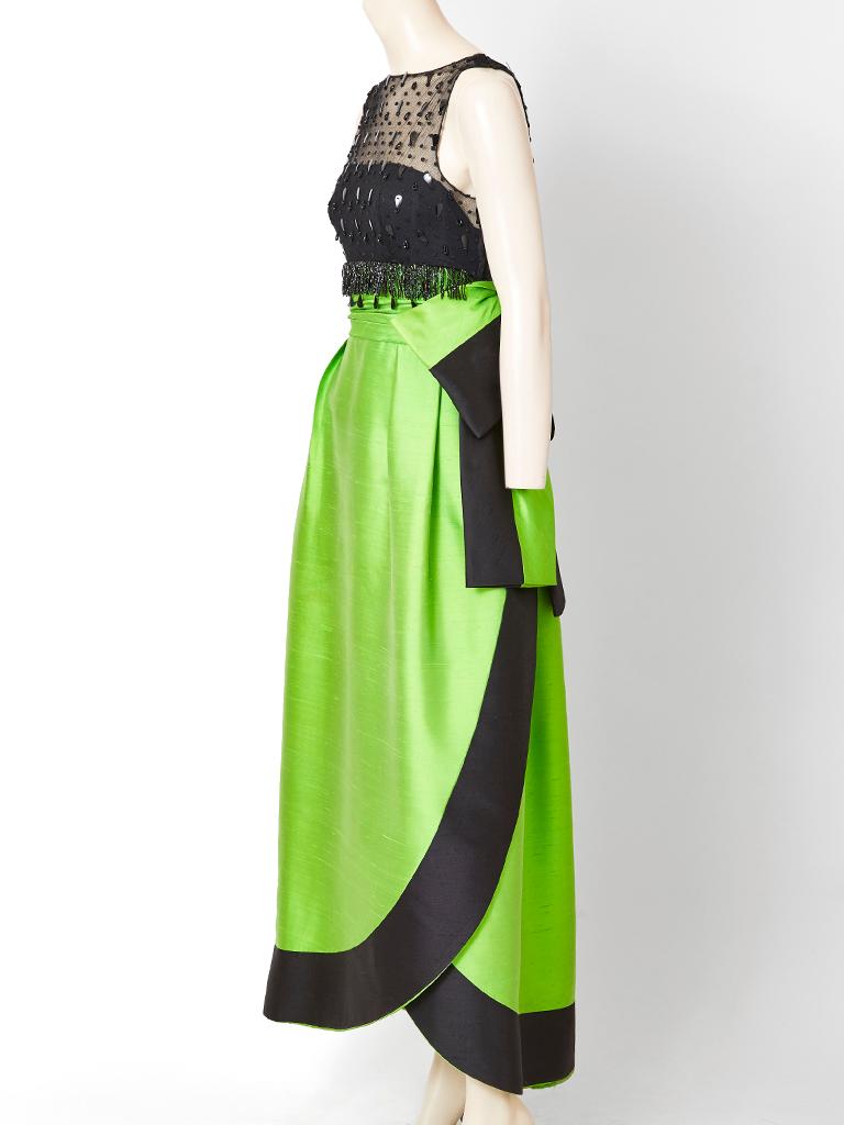 Attributed to Irene Galitzine, sleeveless gown, having a black net bodice embellished with jet beads and sequins. Skirt of the dress is a structured shape, in an emerald  green, tone, having a cummerbund and a two tone large bow.The hem is curved
