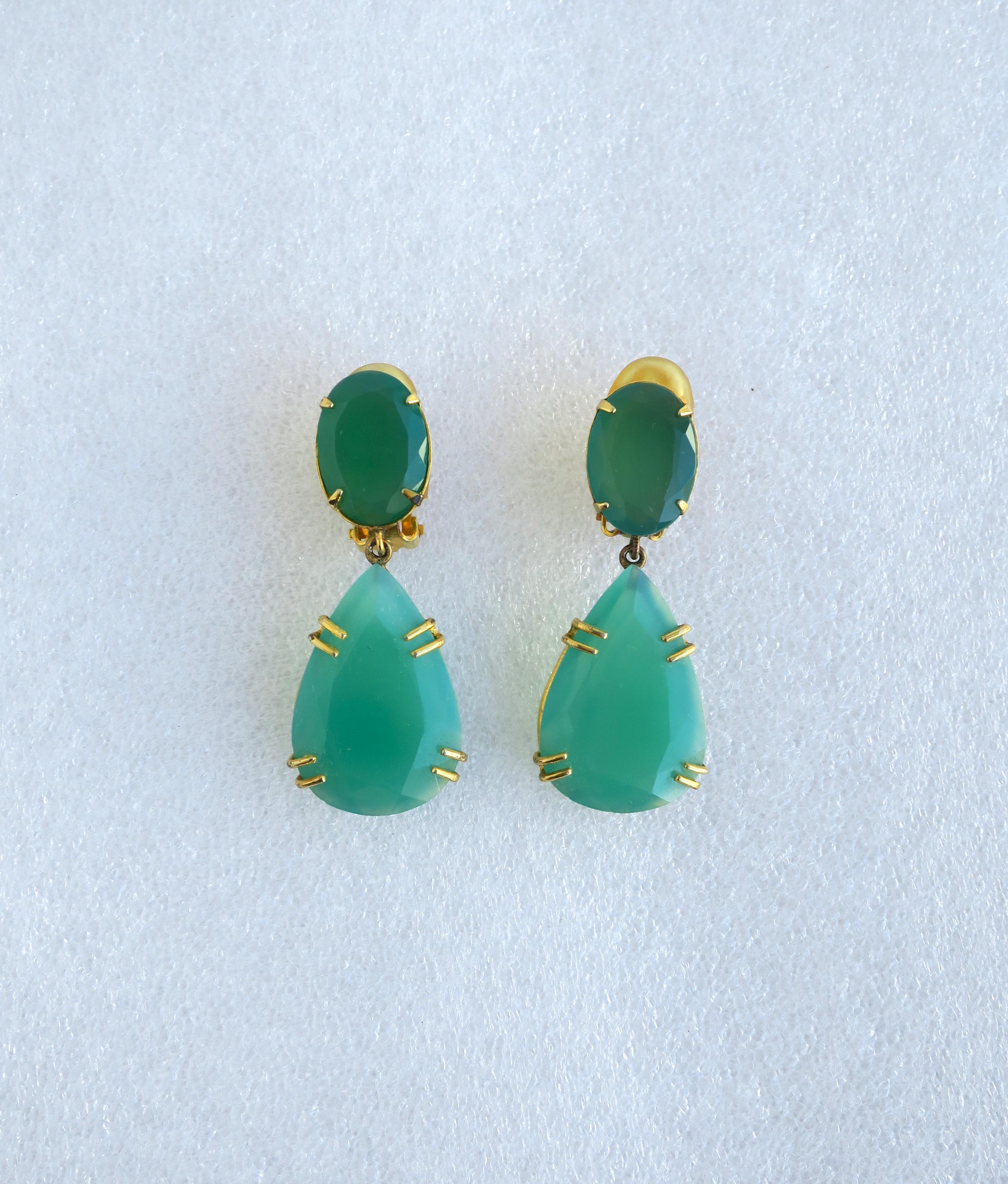 A stunning pair of relatively large Chrysoprase drop earrings featuring faceted oval and marque emerald green Chrysoprase stones, embraced by a gold-tone metal finish setting. Earring backs are clip-on with comfort covered backs. Earrings are