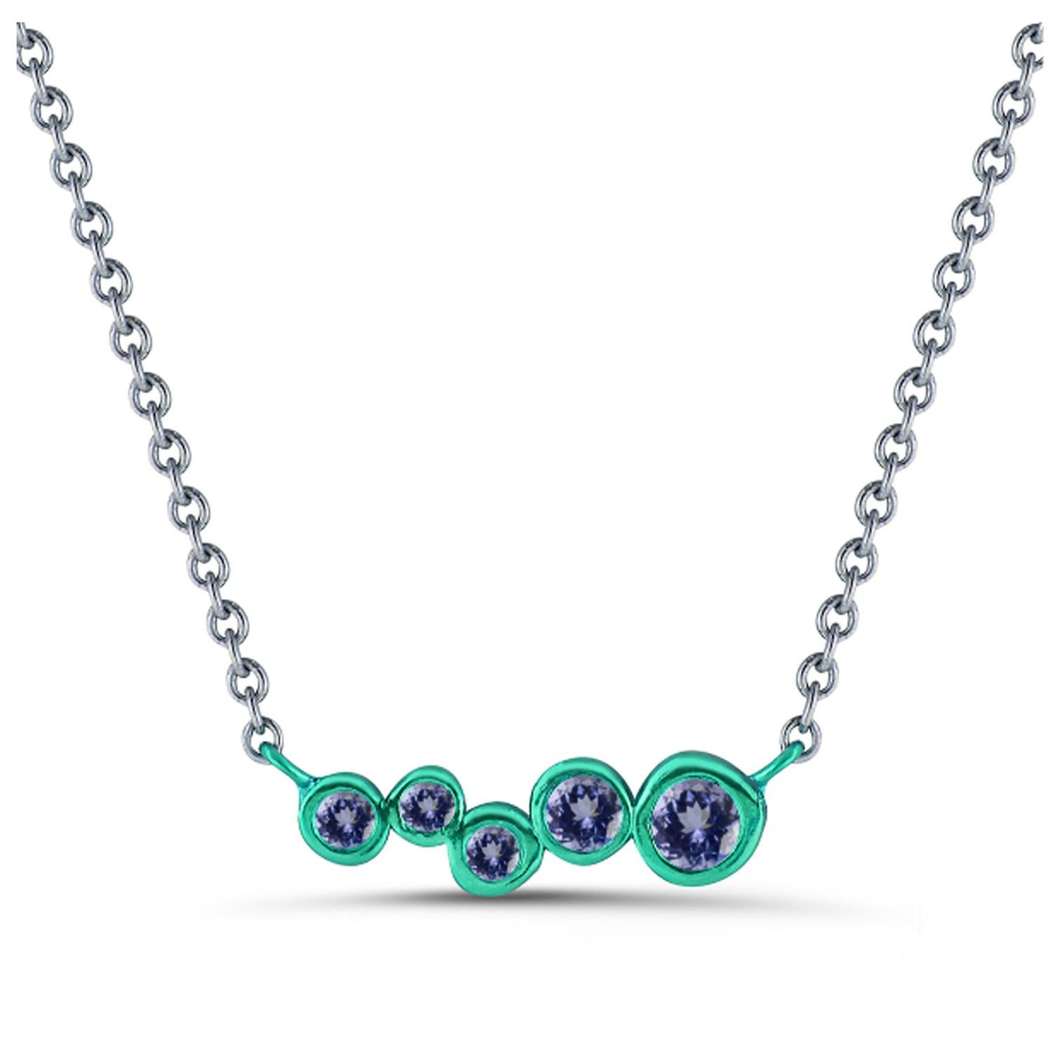 Hi June Parker's version of the classic bar pendant sprinkled with tapering sizes of Tanzanite stones ceramic plated with Emerald Green to add a pop of electric color to your neck.

Inspired by seeing the cross-section view of life, as if slicing a