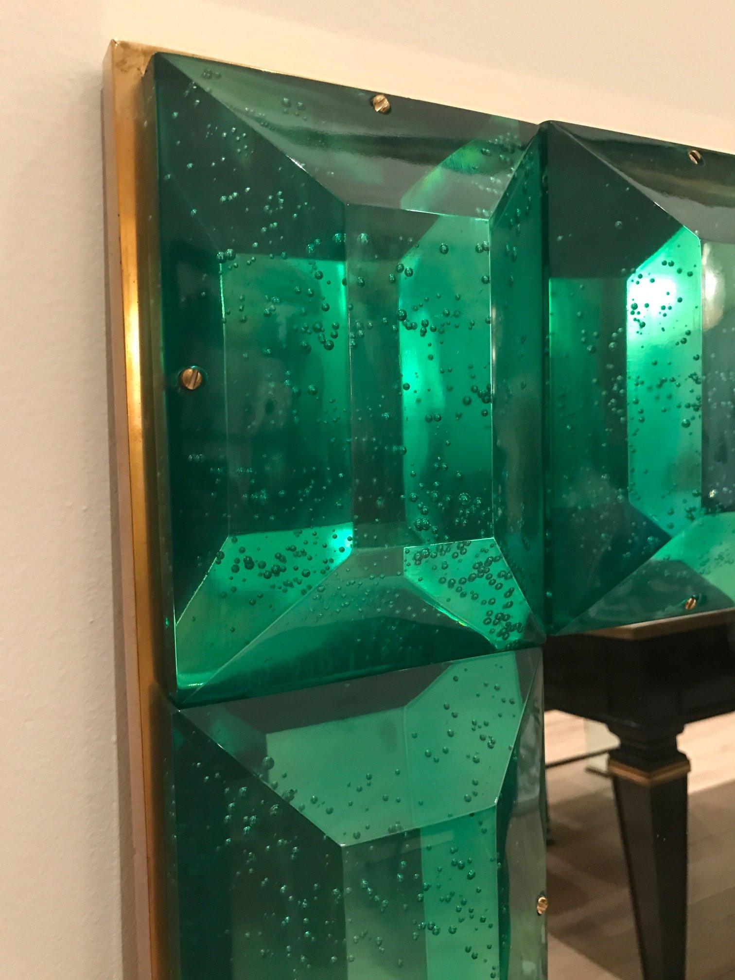  Customizable emerald green diamond cut Murano glass mirror.
 Vivid and intense emerald green glass block with naturally occurring air inclusions throughout 
 Highly polished faceted pattern
 Brass accents
 Luxury handcrafted by a team of artisans