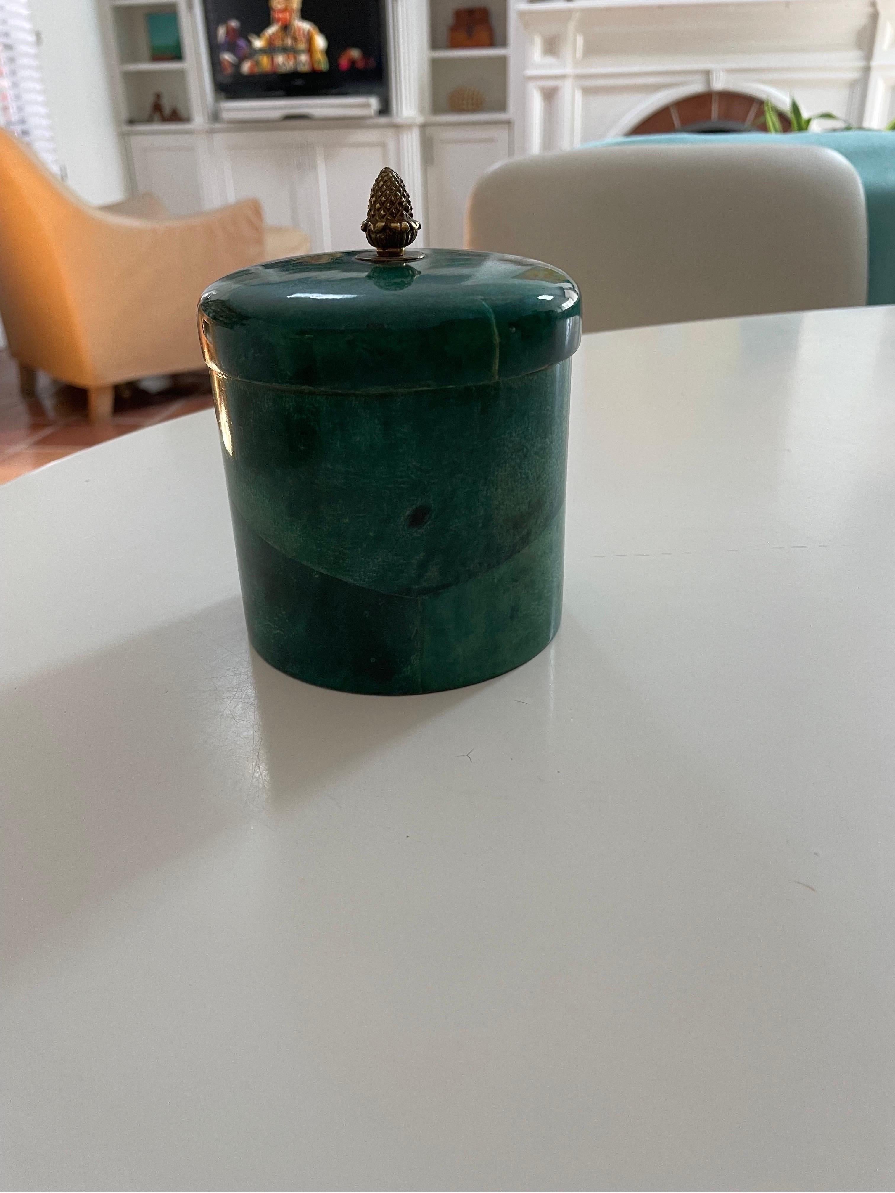 This is a beautiful emerald green goat skin cylinder box with a brass pineapple finial on lid and wooden interior in the style of Aldo Tura.