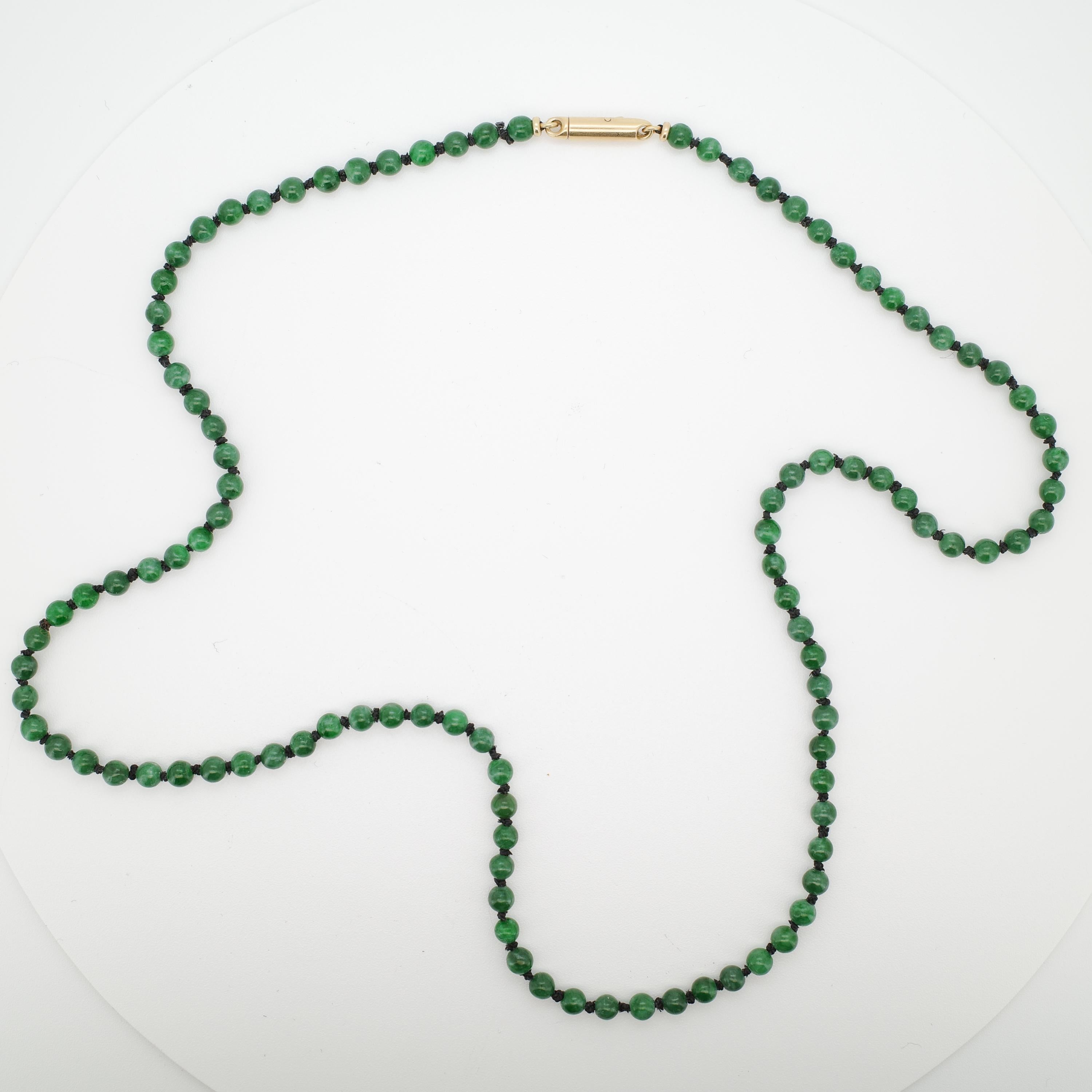 Ce riche collier vert émeraude possède une beauté extravagante. Les perles légèrement tachetées sont de taille et de forme uniformes et possèdent un beau poli.

Ces 103 perles de jadéite fine 