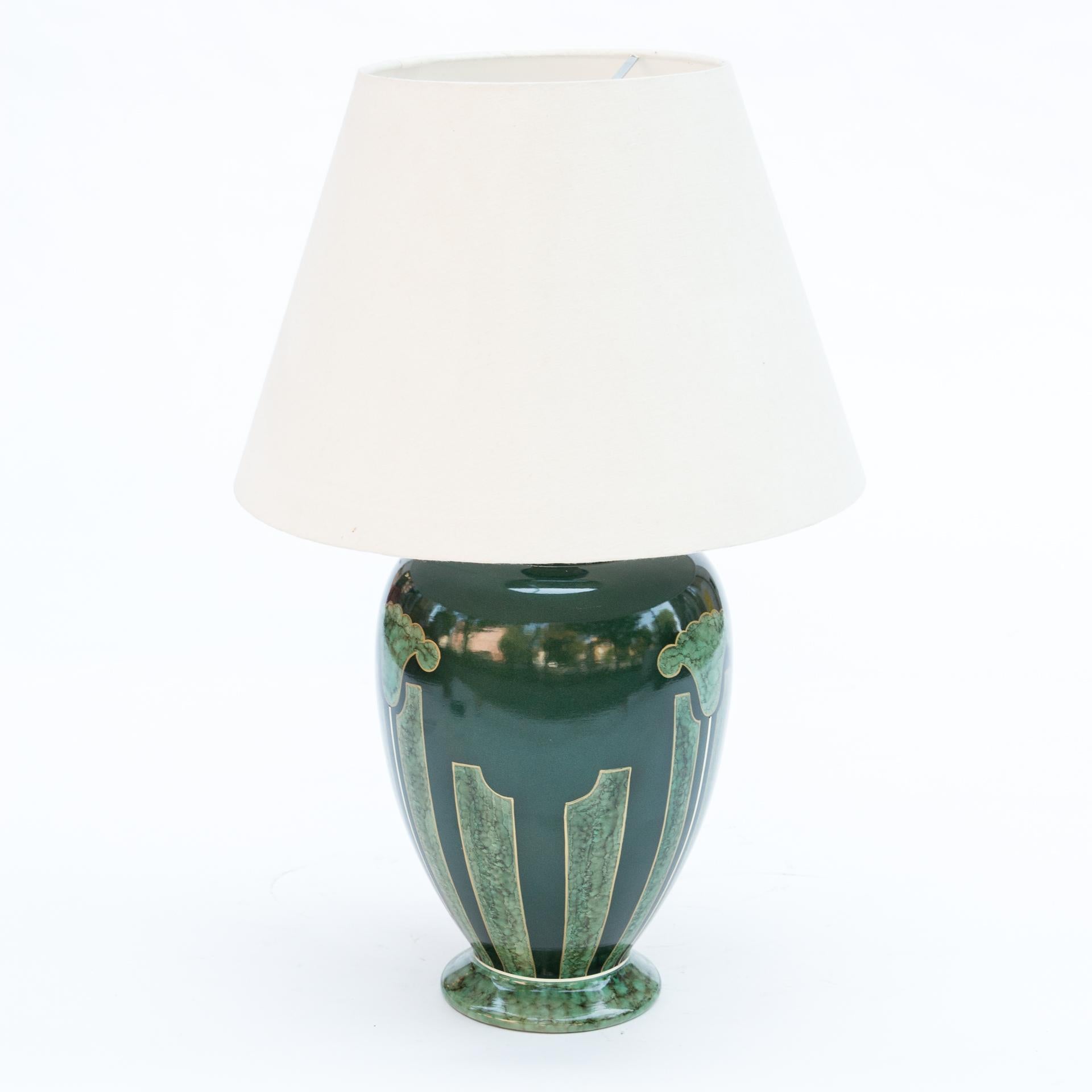 A monumental table lamp in a deep emerald color. It has beautiful Art Nouveau decorations. Hand painted. Signed L. DRIMMER. France - Rodez.

The body of the lamp is a large ceramic vase. It is painted in a deep emerald shade of green. The surface