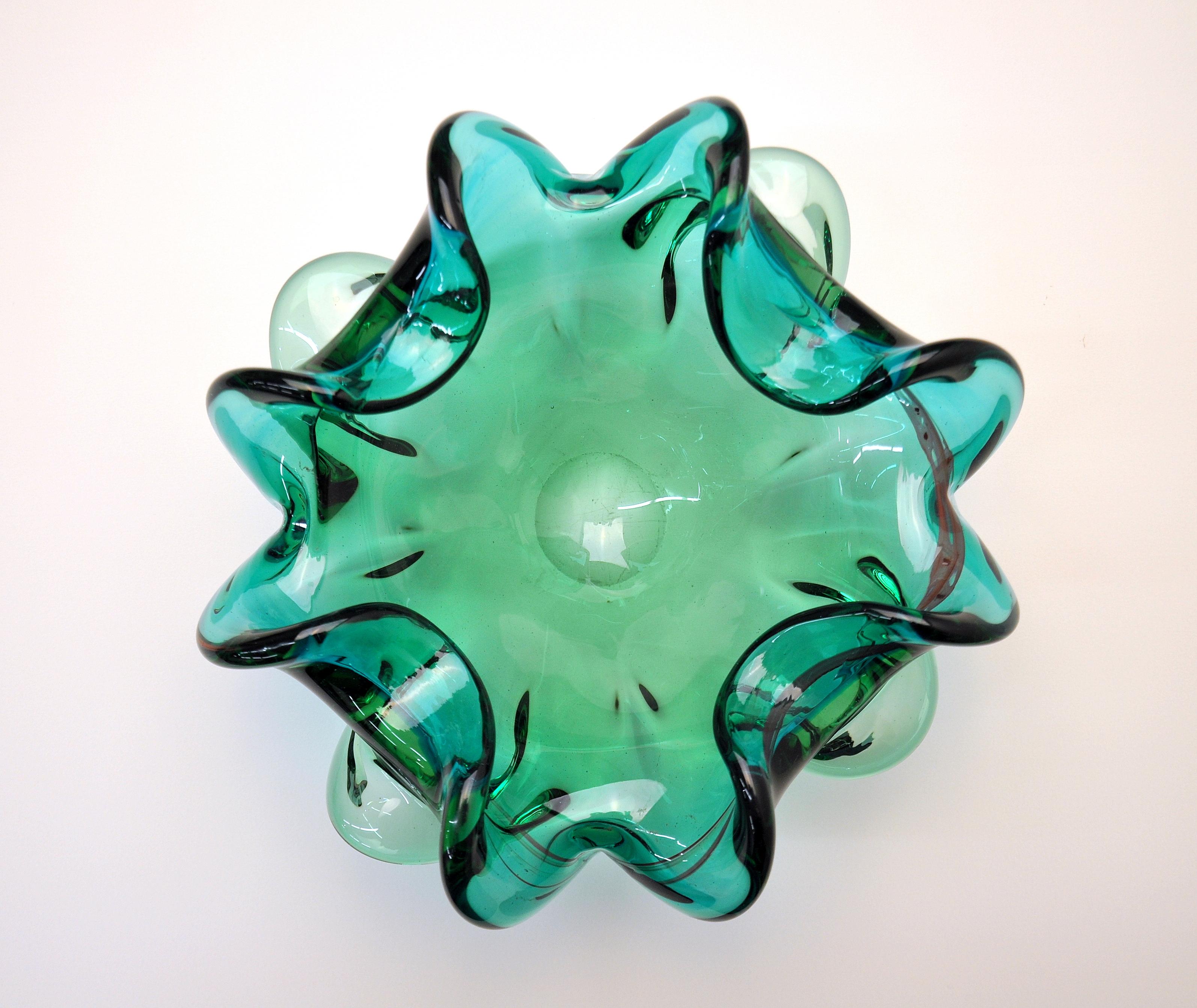 Vintage Mid-Century Modern hand blown Venetian glass vide-poche, decorative bowl or cigar ashtray with organic floral form. It features a vibrant hue of jewel tone green and pinched rims with flared sides. A great example of Italian Mid-Century