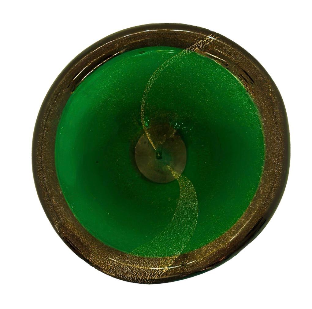 Handcrafted by skilled artisans of Murano, this glass bowl showcases the vibrant colors and intricate detail that characterize the island's tradition of glassmaking. An exquisite deep green color with swirls of shimmering gold avventurina, this bowl