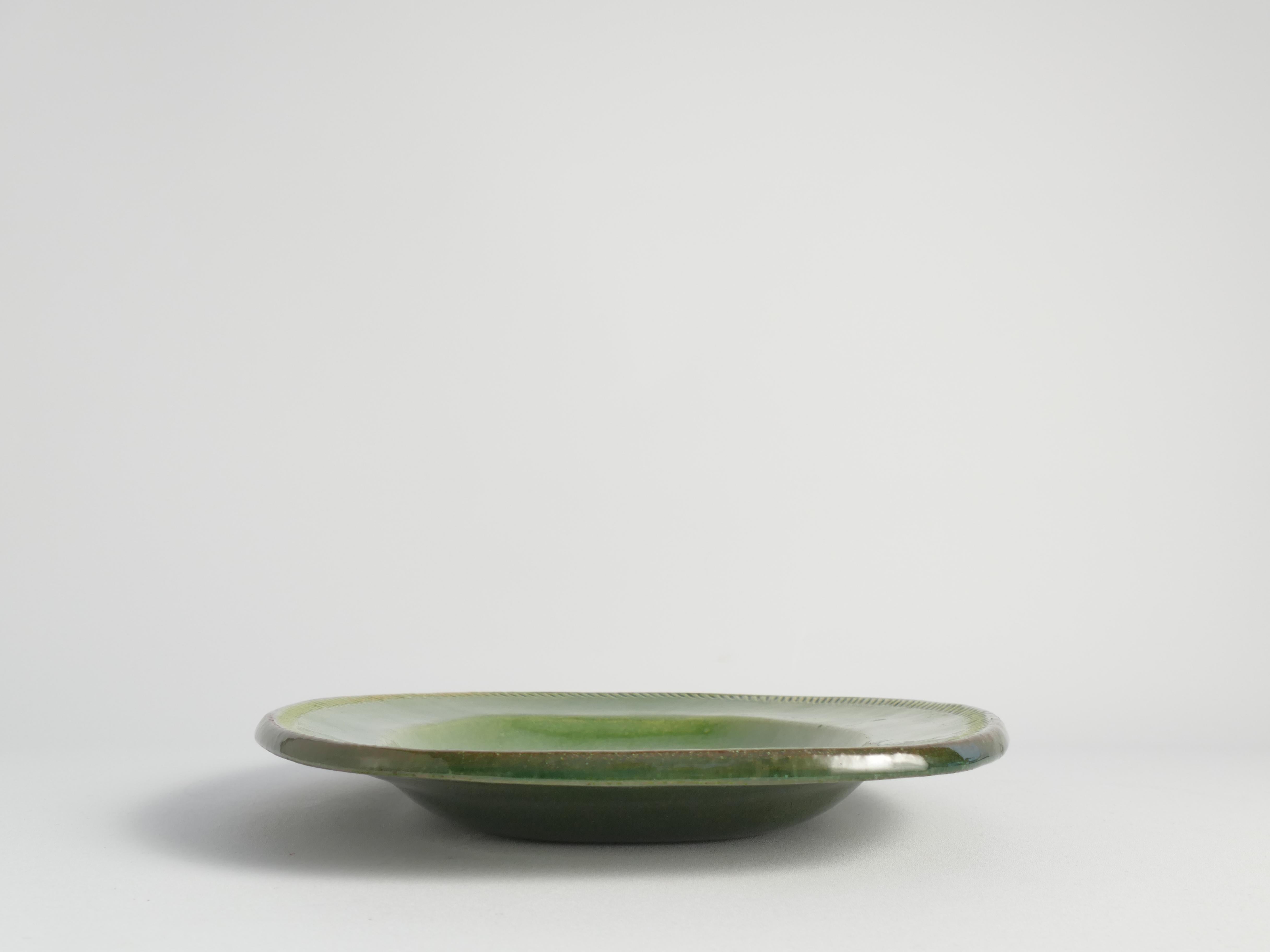 Ce magnifique plat décoratif scandinave moderne en grès vert émeraude est conçu et fabriqué à la main par Andersson & Johansson, Höganäs.

Le plat est marqué en dessous de timbres profonds indiquant 