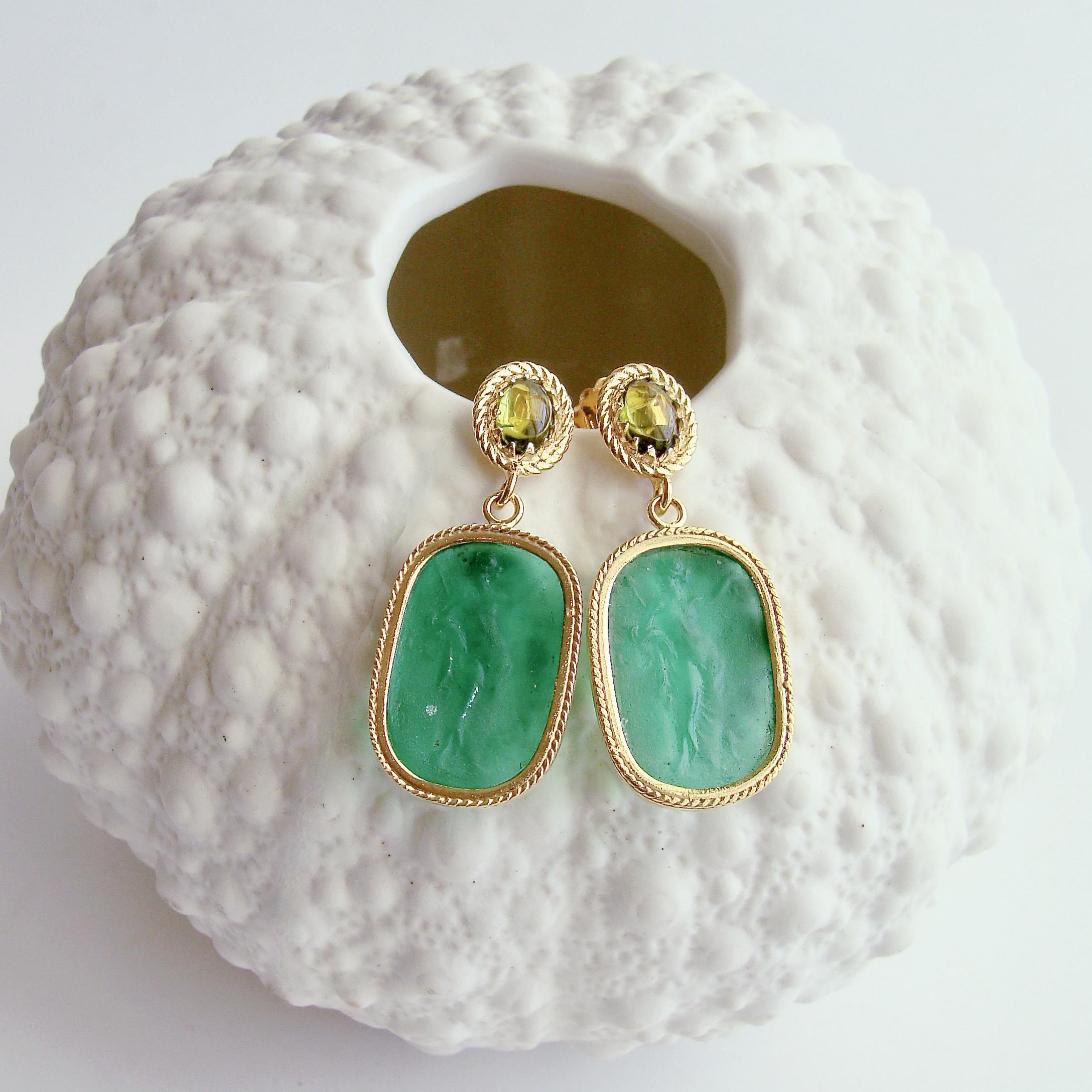 Rich emerald green Venetian glass Neoclassical intaglios sway gently below a pair of smooth peridot post style earrings to create these sunning neoclassical earrings.  The draped goddess is an often recreated style and this particular one has been