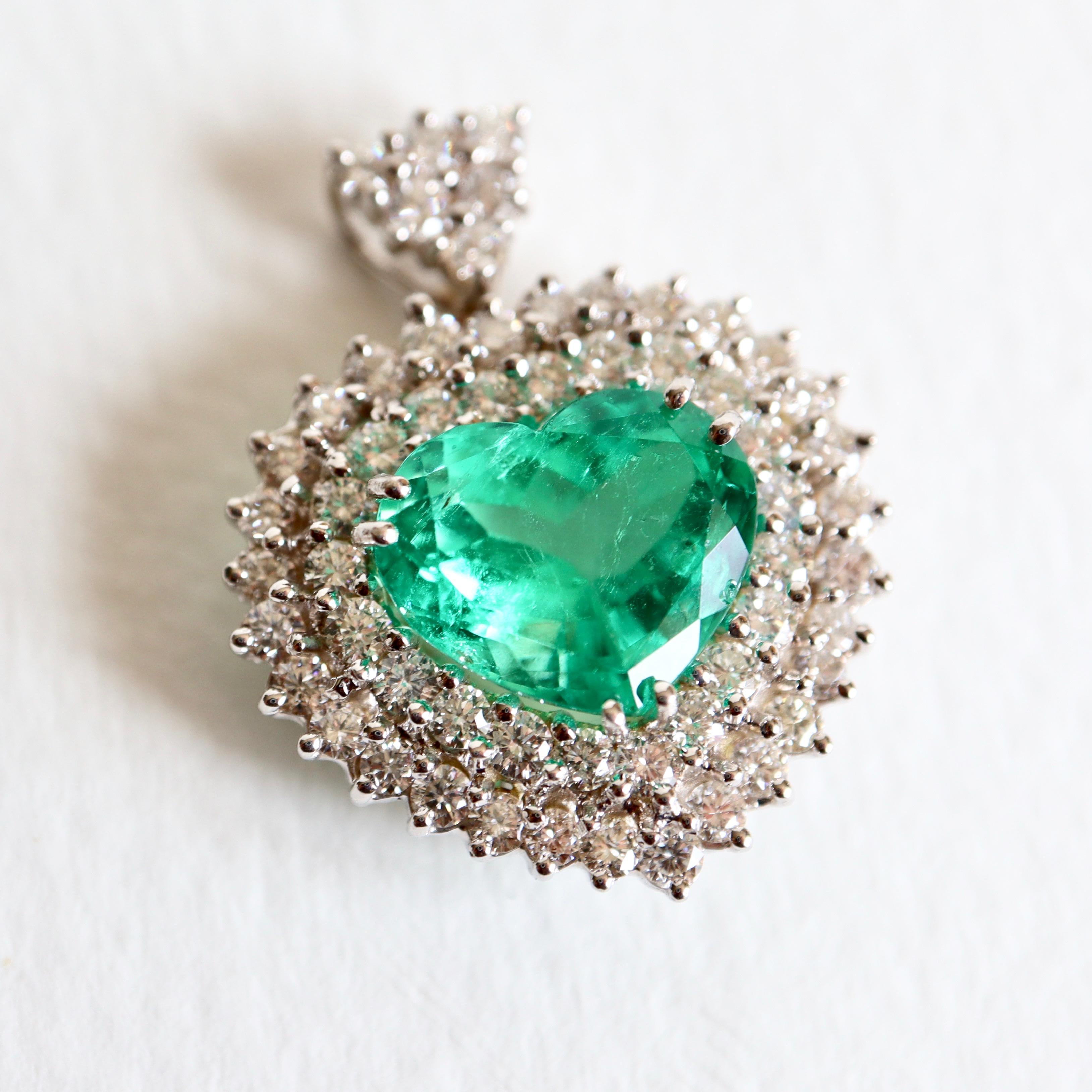 Pendant setting two Rows of Diamonds retained by an articulated Bail set with Diamonds for 1.46 Carats of Diamonds in Total. This Pendant holds in its Center an important Heart Cut Emerald weighing 4.63 Carats. Certificate n ° 24 Colombia resin and