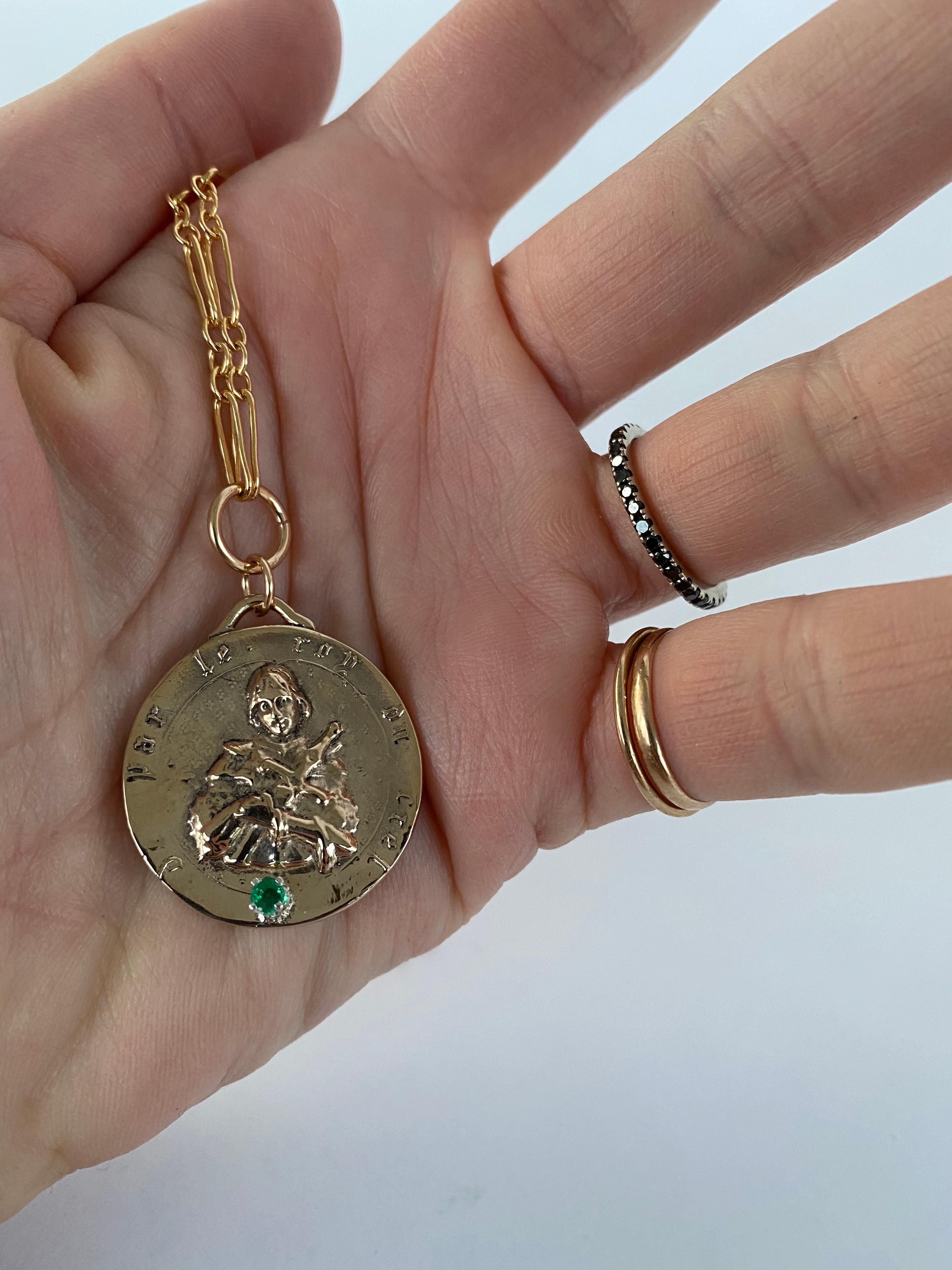 Smeraldo incastonato su un ciondolo a forma di medaglia di Giovanna d'Arco, la collana a catena grossa è riempita d'oro J Dauphin

Pezzo esclusivo con ciondolo a forma di moneta rotonda della Medaglia di Giovanna d'Arco in bronzo con uno smeraldo e