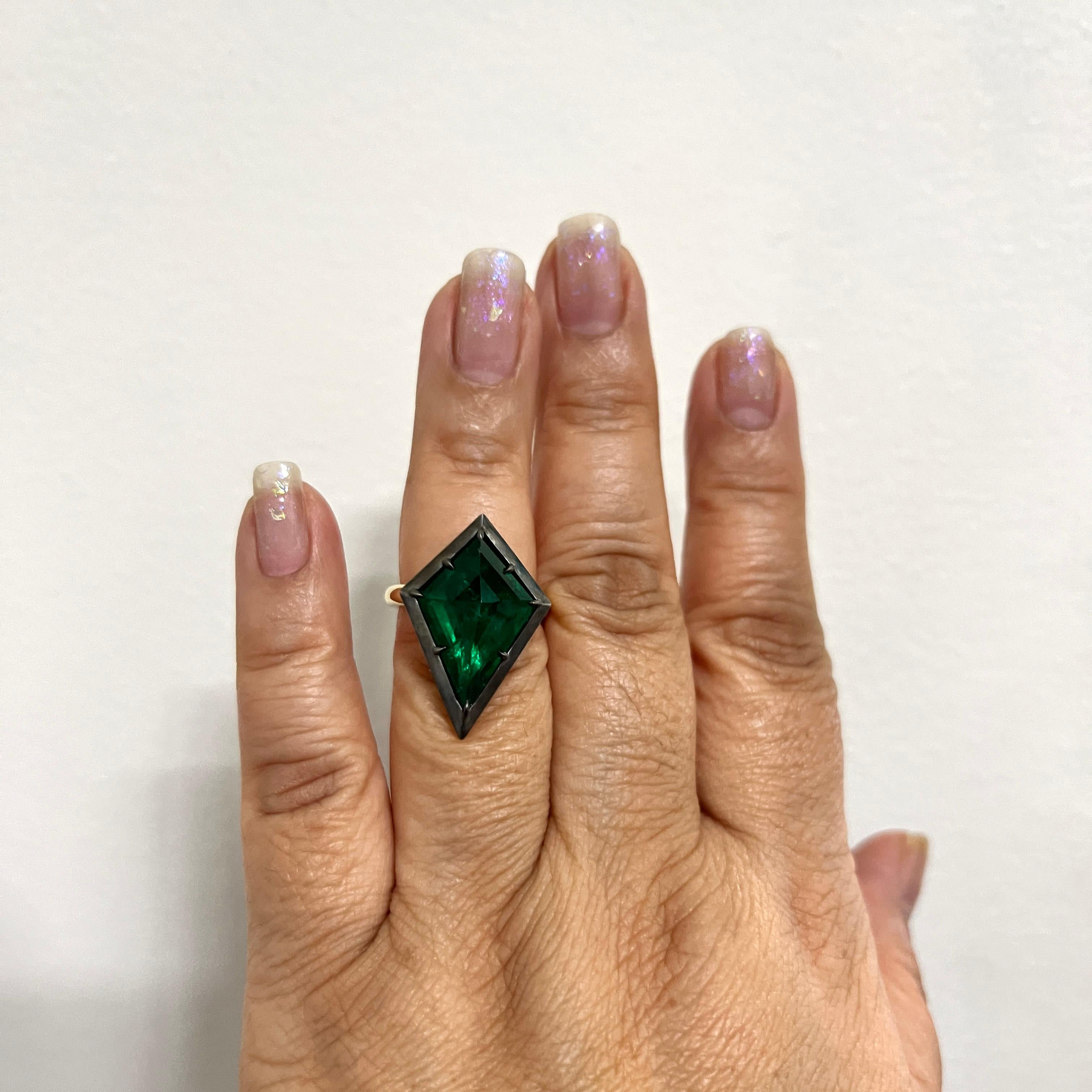 Amazing 8.08 ct. emerald kite shape handmade in 18k yellow gold and black rhodium ring.  This stone is so unique and the setting is edgy.  A great piece to add to any fine jewelry collection.  Ring size 6.5.
