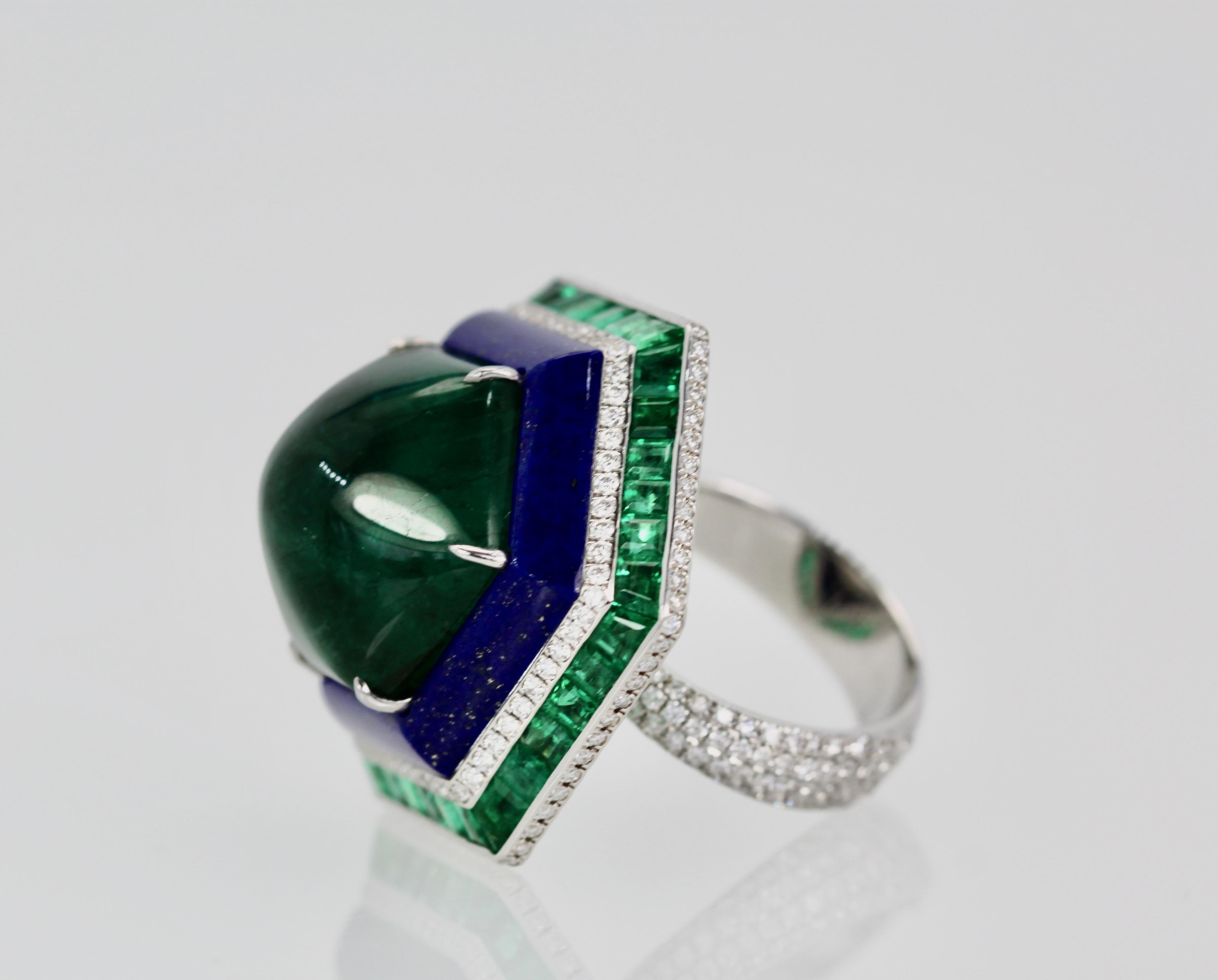 This modern Emerald Lapis and Diamond ring is absolutely exquisite and made in 18K white gold.  There are 48 square Emeralds surrounding a Lapis band that circles this amazing 29 carat Sugarloaf Bullet Emerald. No details have been missed including