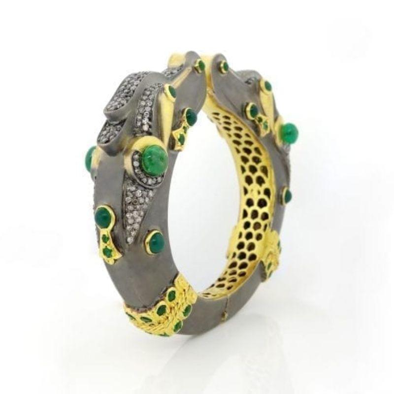 Dragon Bracelet containing emerald mix of about 12.00 carats and round diamonds of about 4.49 carats. All stones are set in 14k yellow gold and silver. Total weight of the bangle is approximately 91.67 grams (1.20g of gold and 90.47 of silver).
