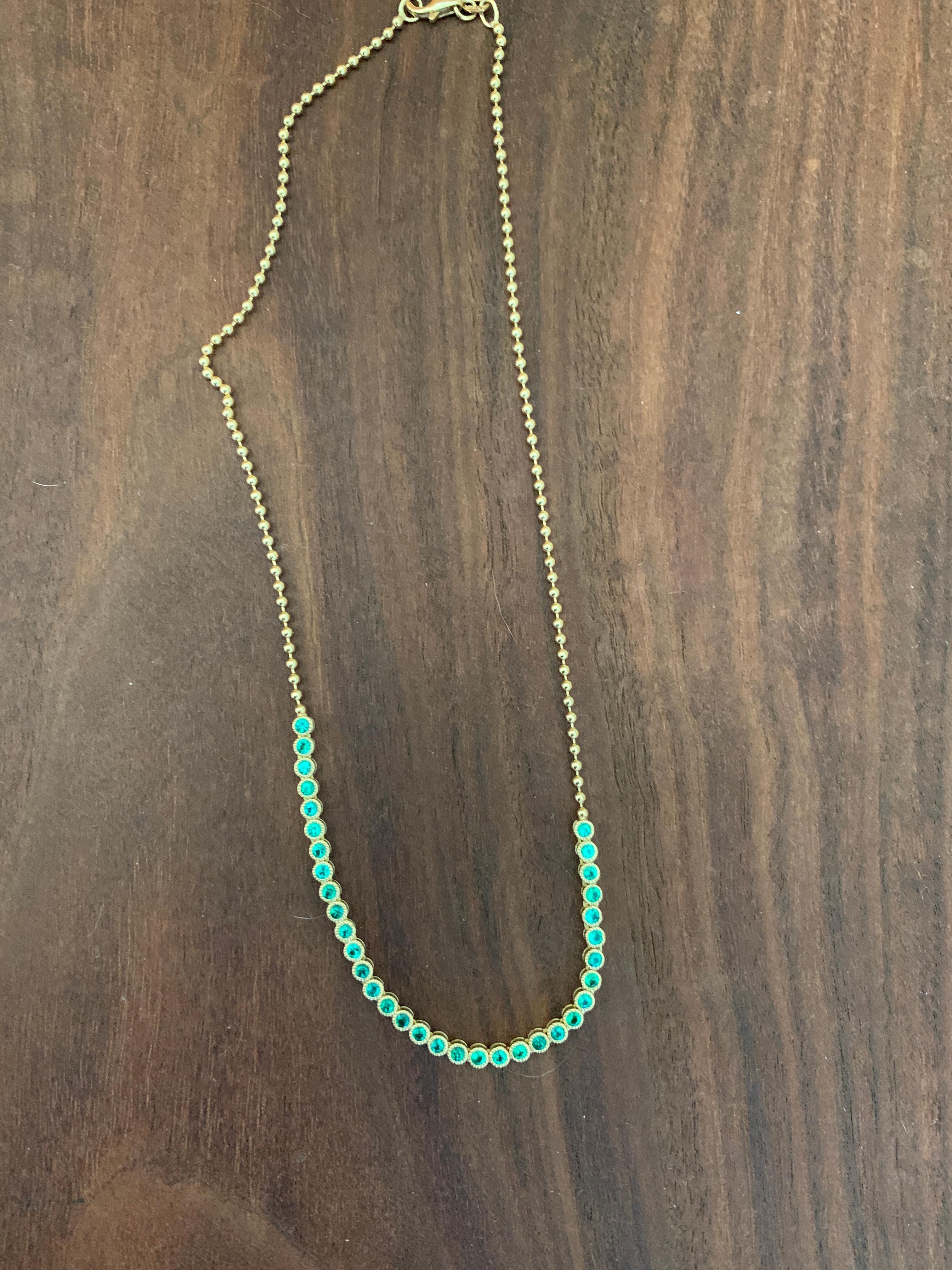 An Emerald Necklace on an 18 Karat Gold Chain. This Necklace is handcrafted in 18-Karat Solid Yellow Gold and is detailed in 34 Emeralds.  Emerald total  Carat weight is 1.60.  This Necklace measures 16.5-in. long and is finished with a lobster