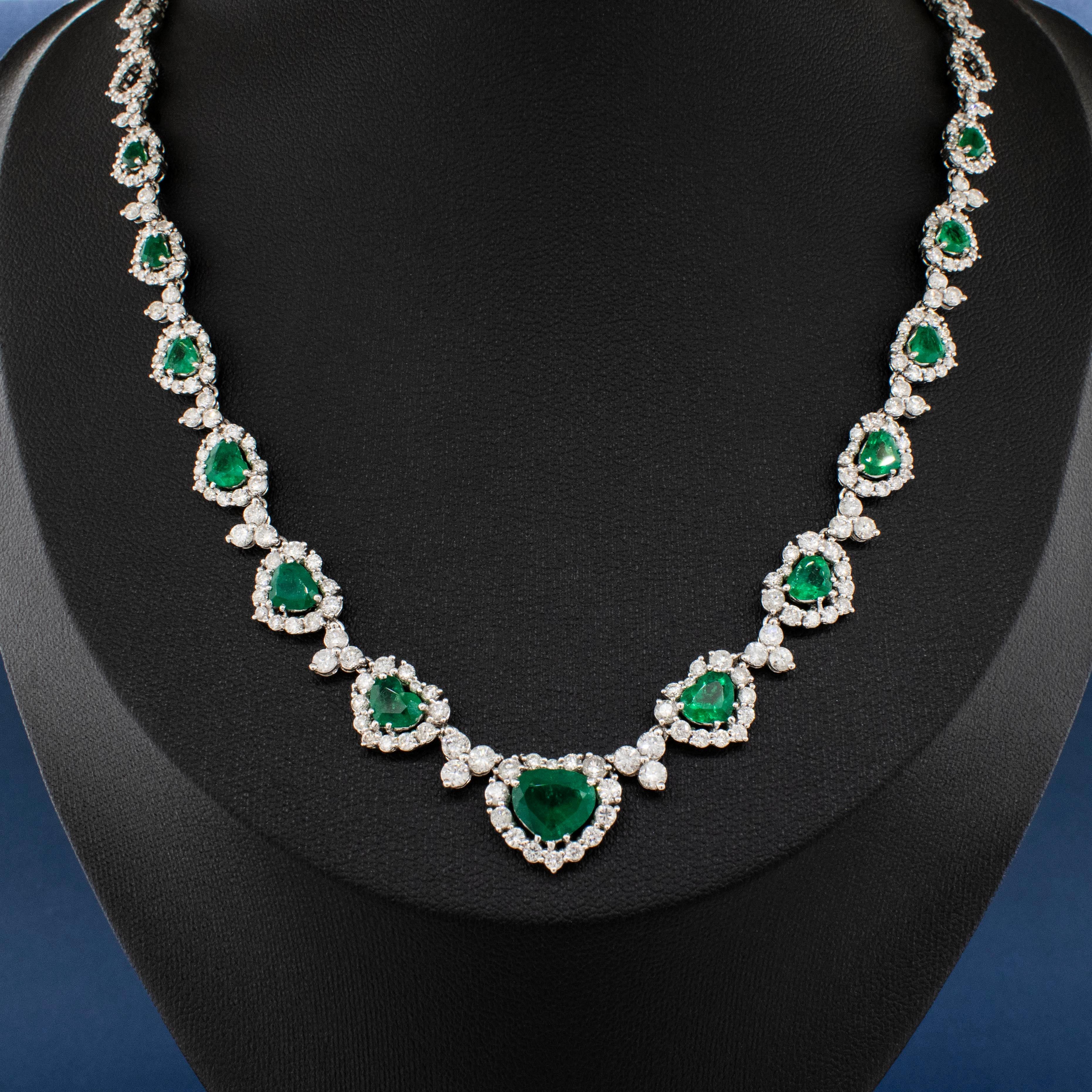 Una collana in oro bianco 18 ct. montata con smeraldi naturali di qualità e diamanti tondi taglio brillante. Ci sono 13 smeraldi a forma di cuore per un peso di circa 6,08 carati. Ognuno di essi è di un verde intenso e vibrante, ben assortito per